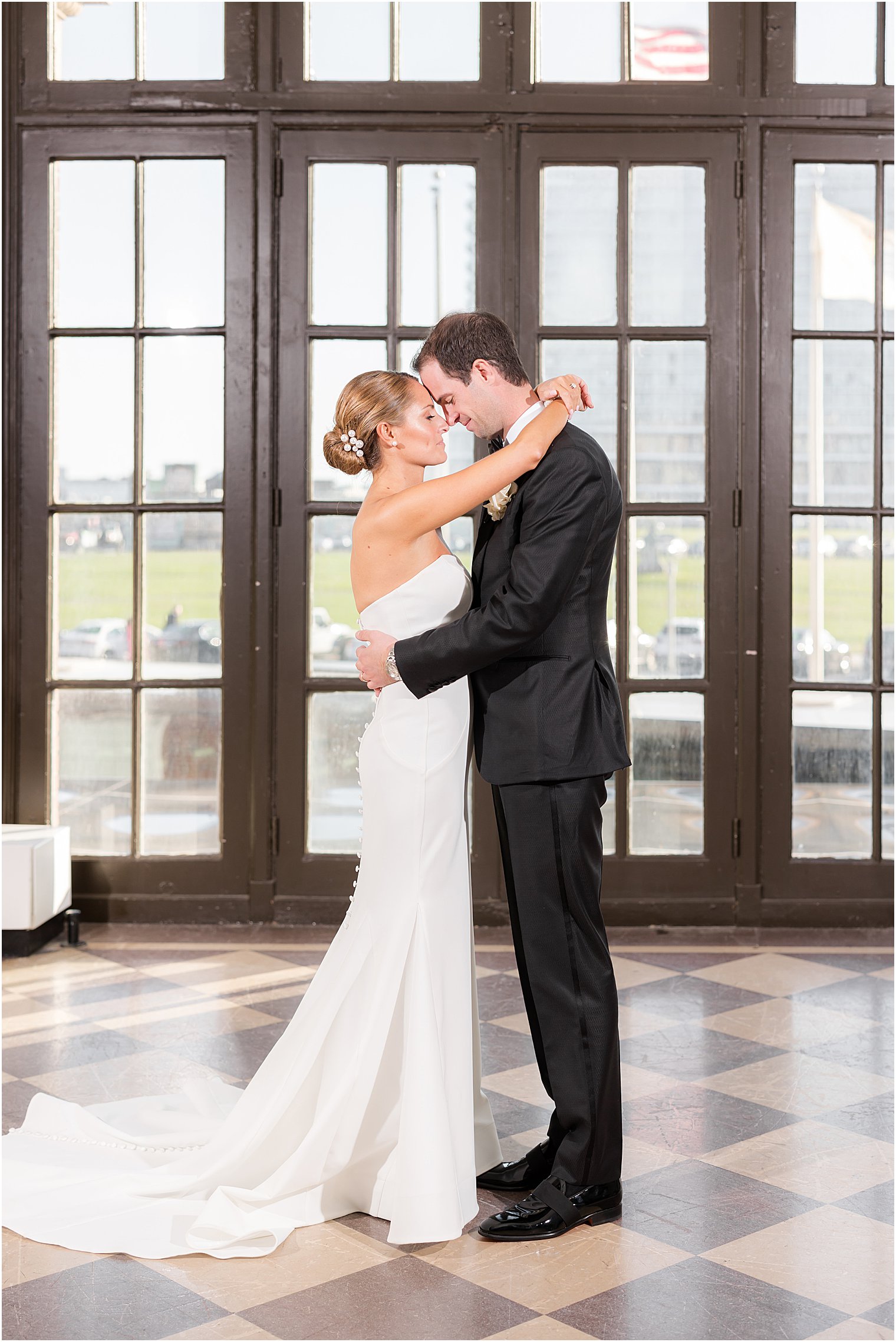 bride hugs groom around his neck during portraits at the Berkeley Oceanfront Hotel