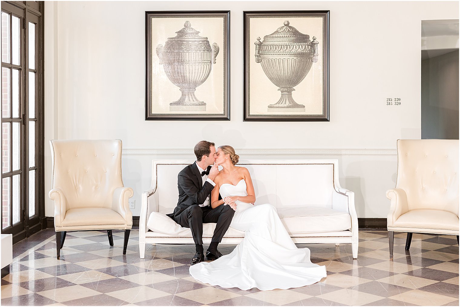 newlyweds kiss sitting on bench inside the Berkeley Oceanfront Hotel