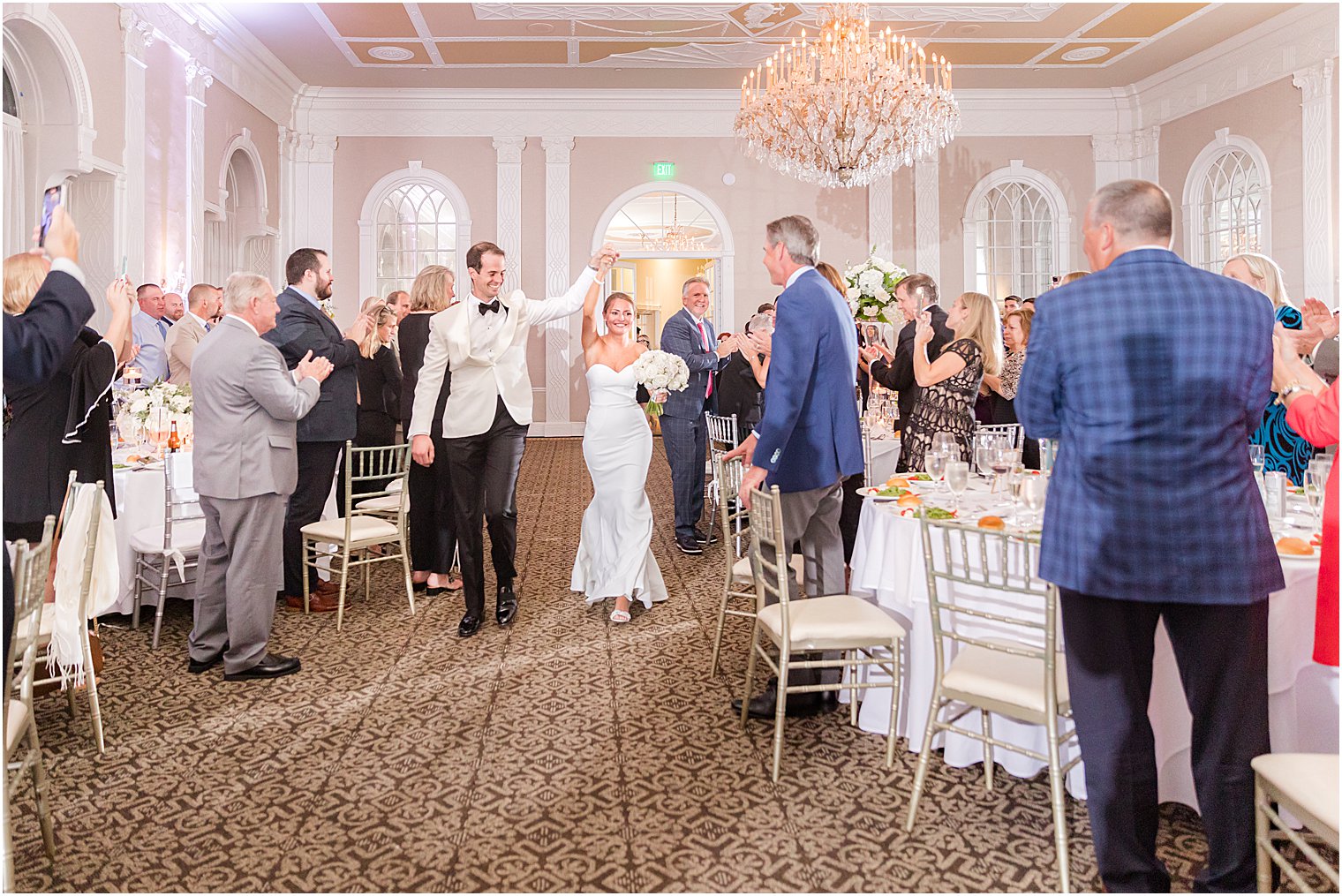 newlyweds hold hands walking into reception at the Berkeley Oceanfront Hotel