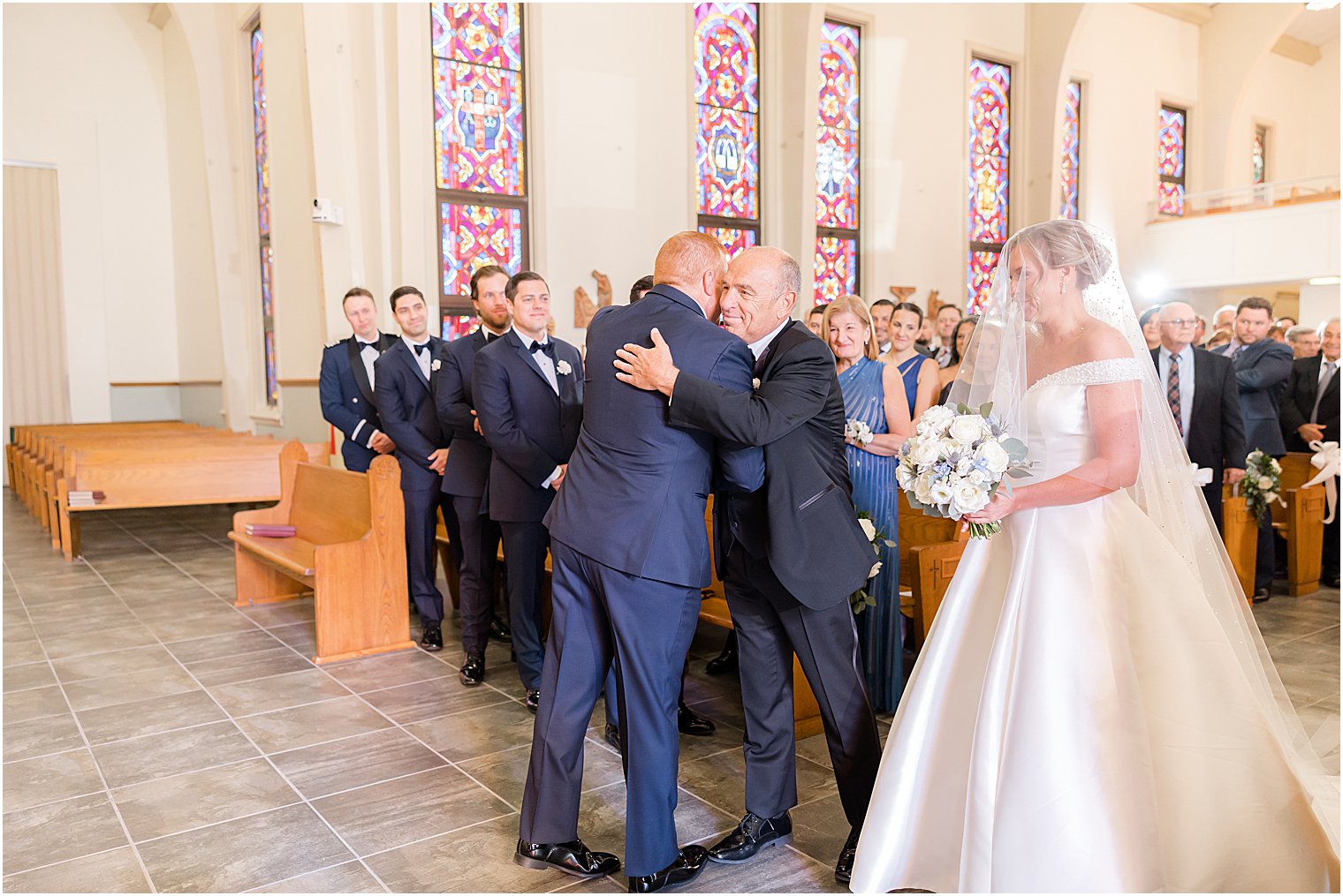 father of bride hugs groom during traditional church wedding on Long Beach Island