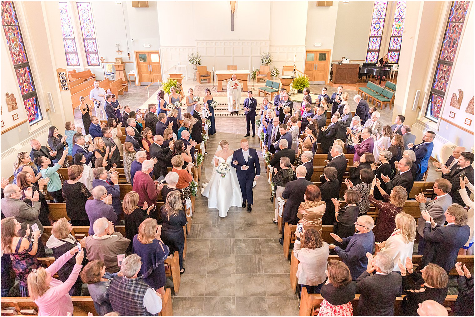 newlyweds recess up aisle after traditional church wedding on Long Beach Island