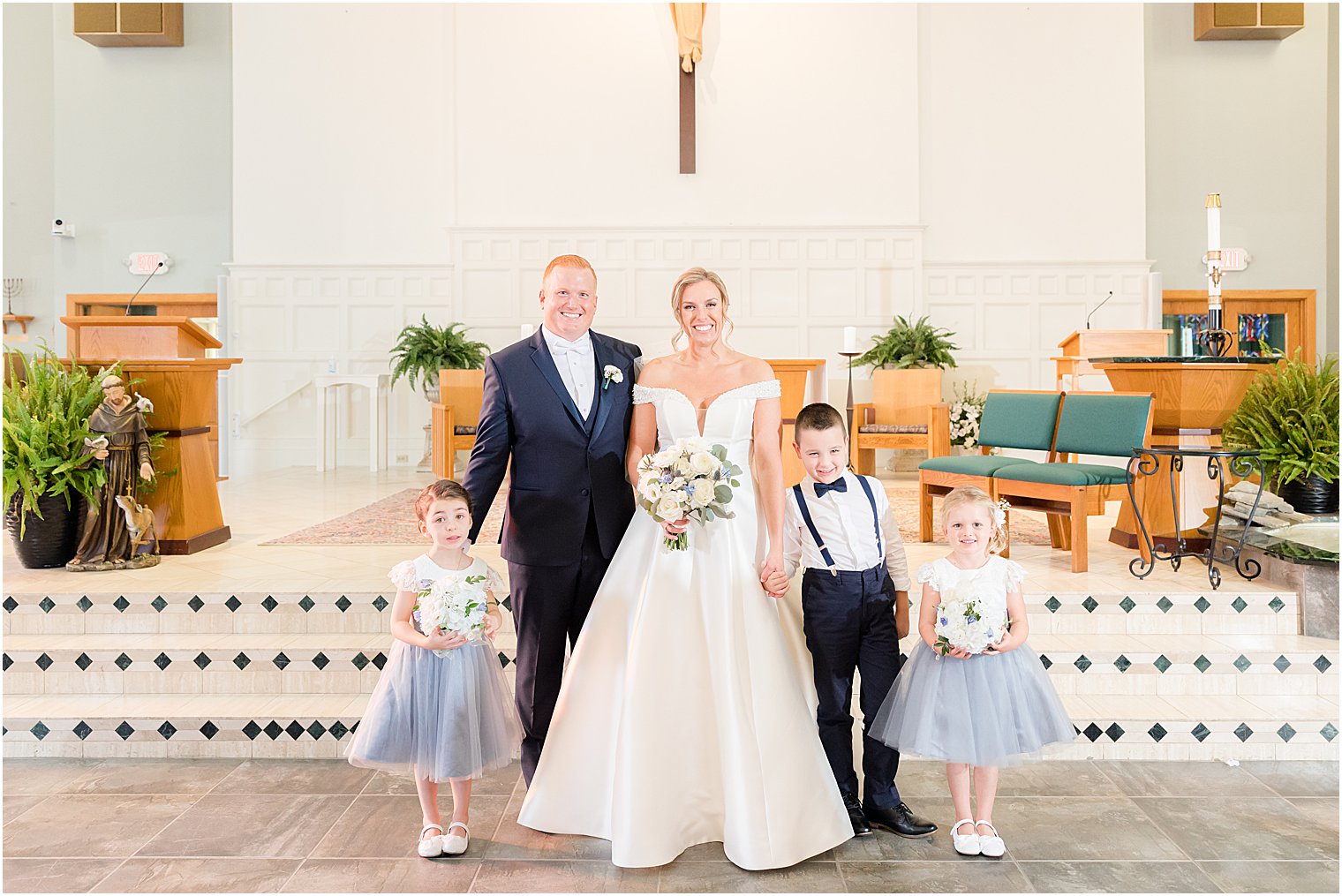 bride and groom pose with flower girls and ring bearer 