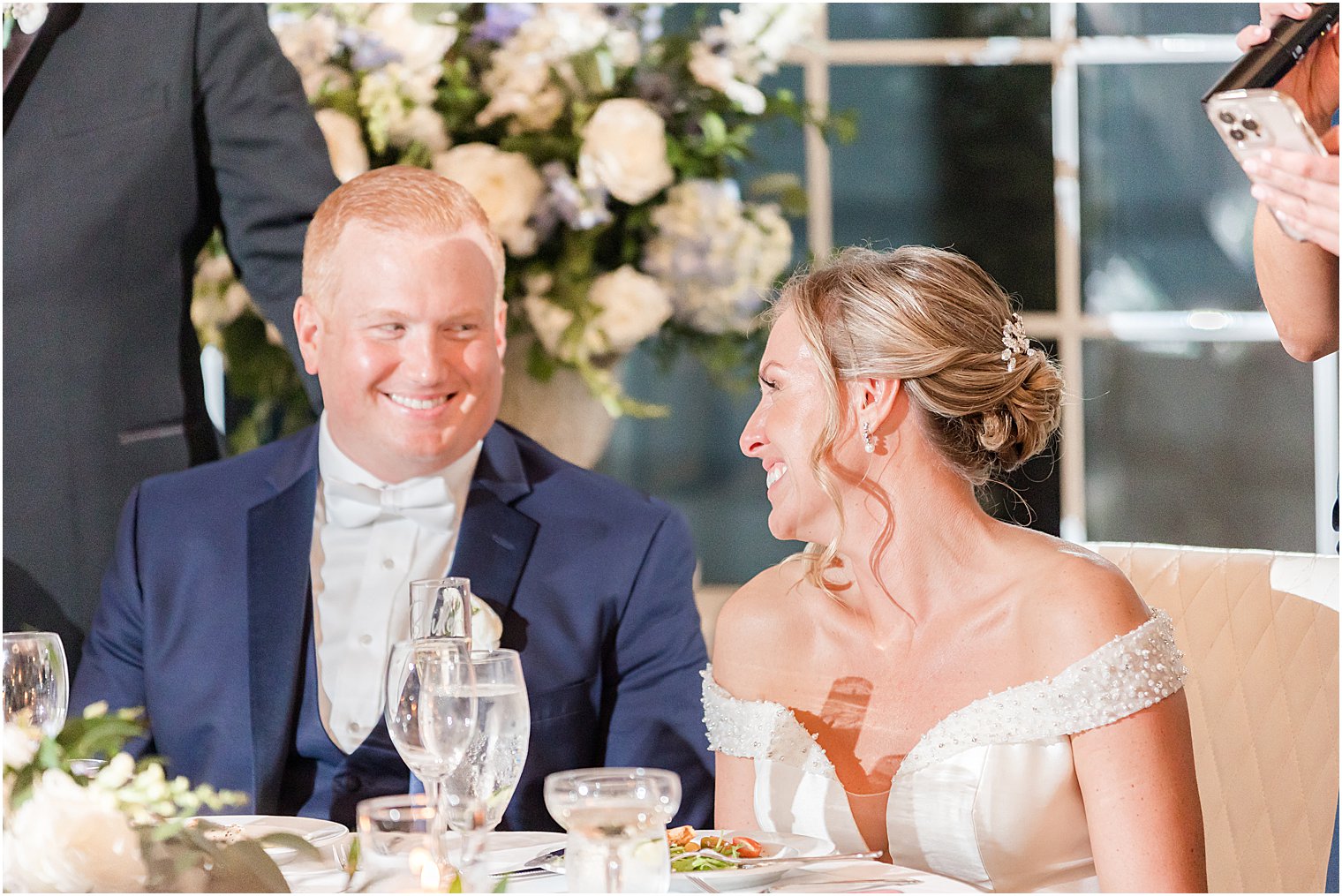 bride and groom smile at sweetheart table during LBI wedding reception 