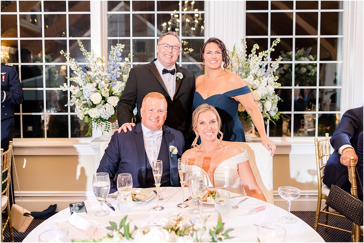 bride and groom sit with maid of honor and best man during LBI wedding reception