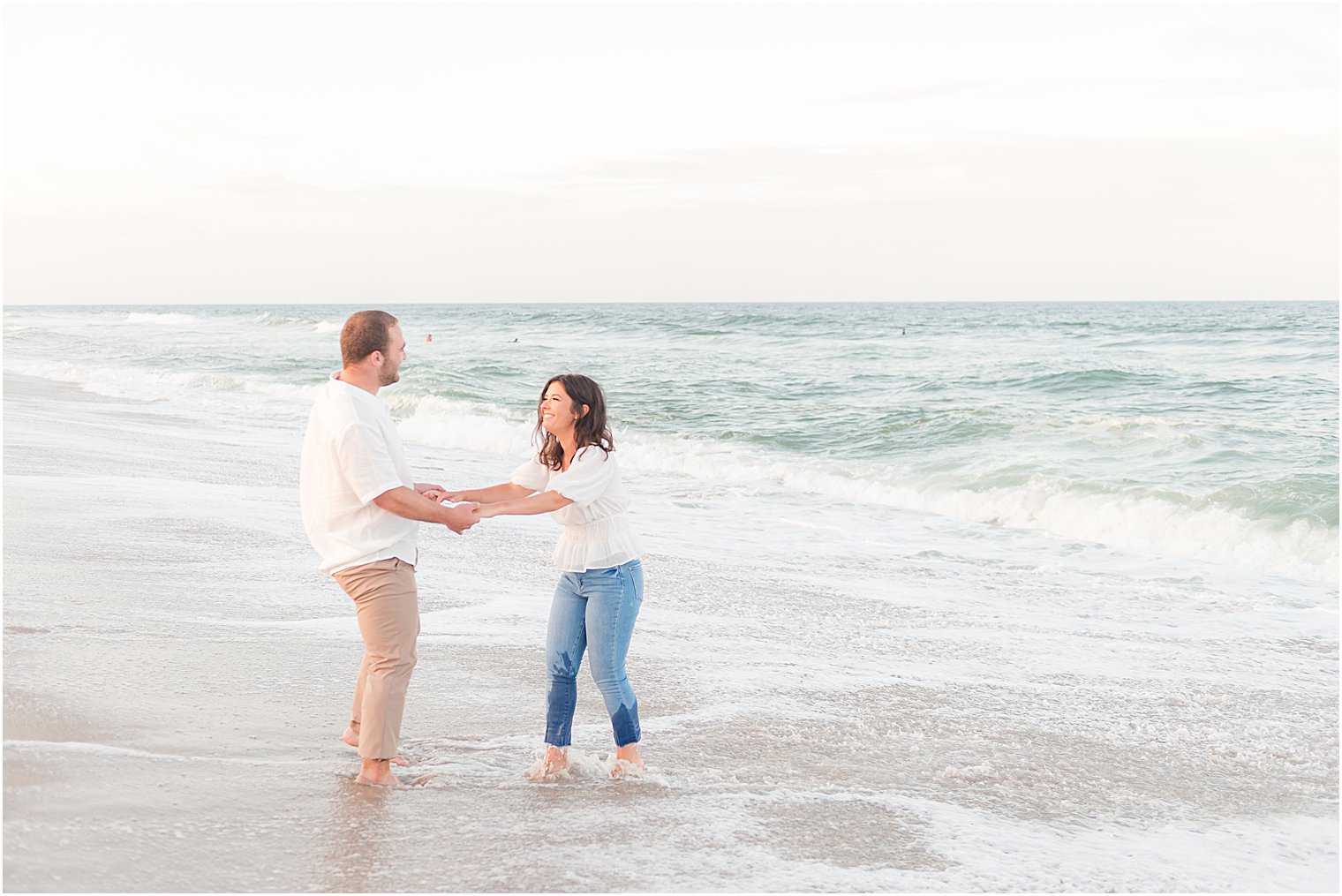 bride and groom play in water on Lavallette Beach