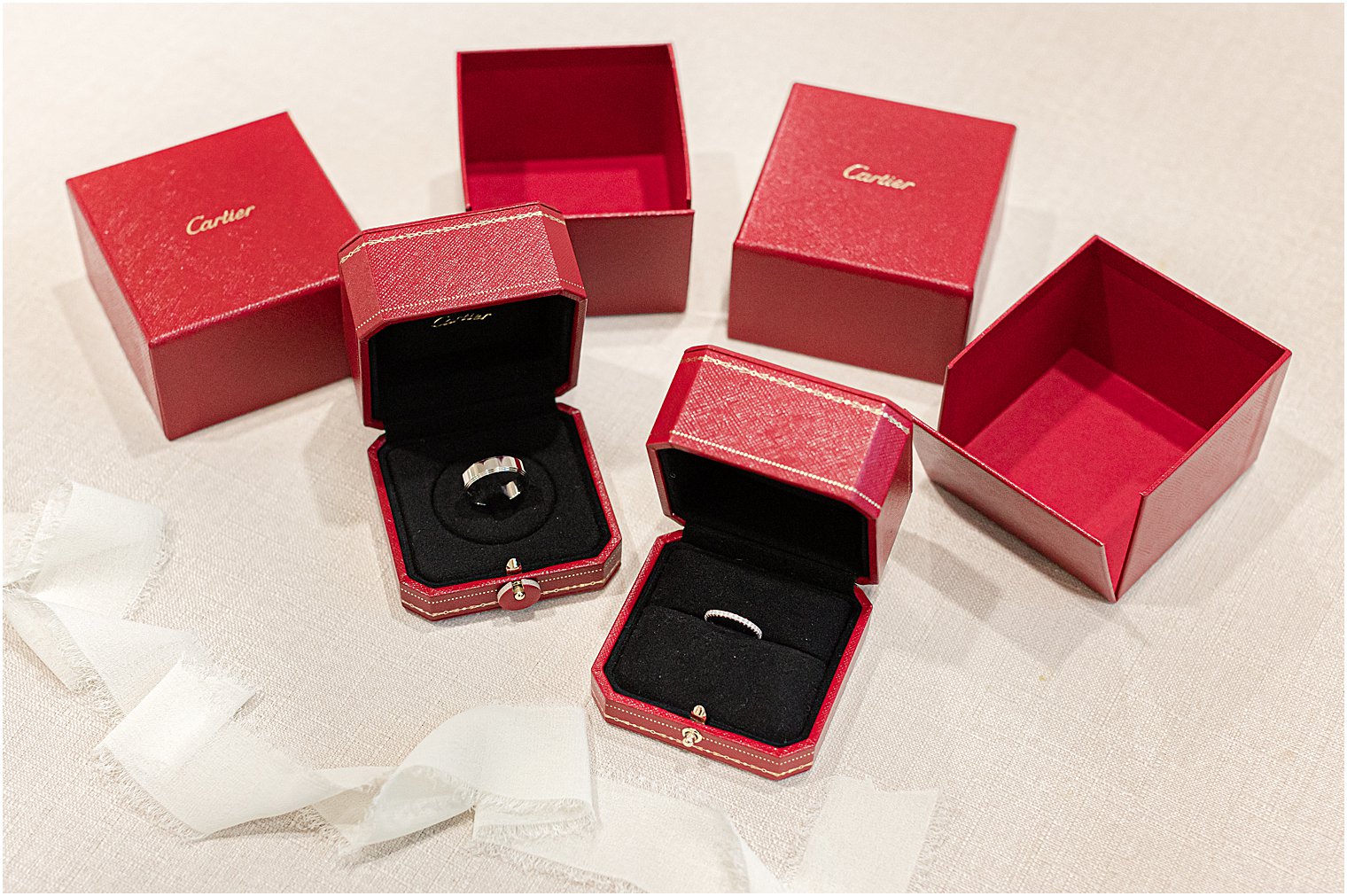 wedding rings rest in red boxes