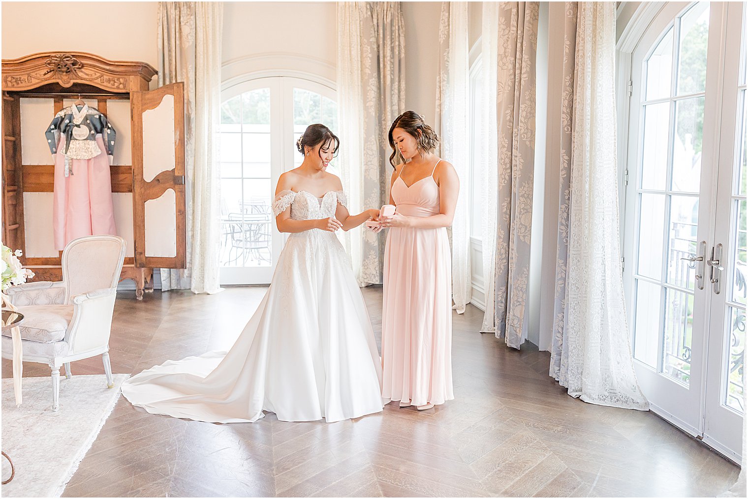 bridesmaid helps bride with prep for fall Park Chateau Estate wedding