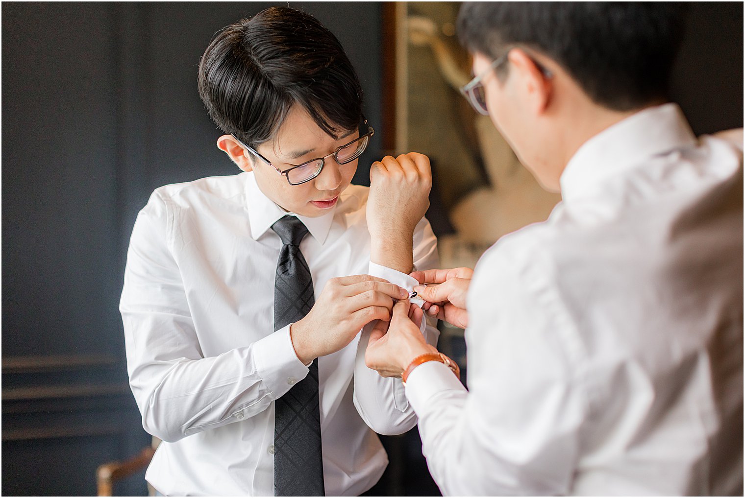 groom adjusts cufflinks for fall Park Chateau Estate wedding