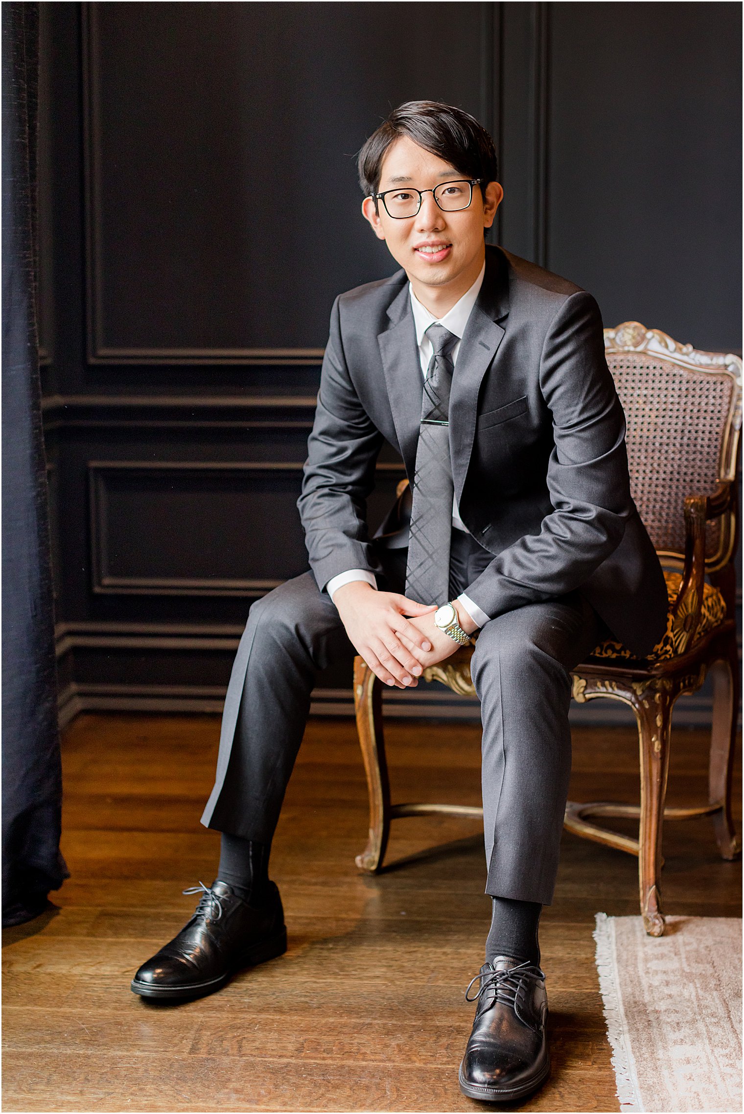 groom sits in silver chair at Park Chateau Estate 