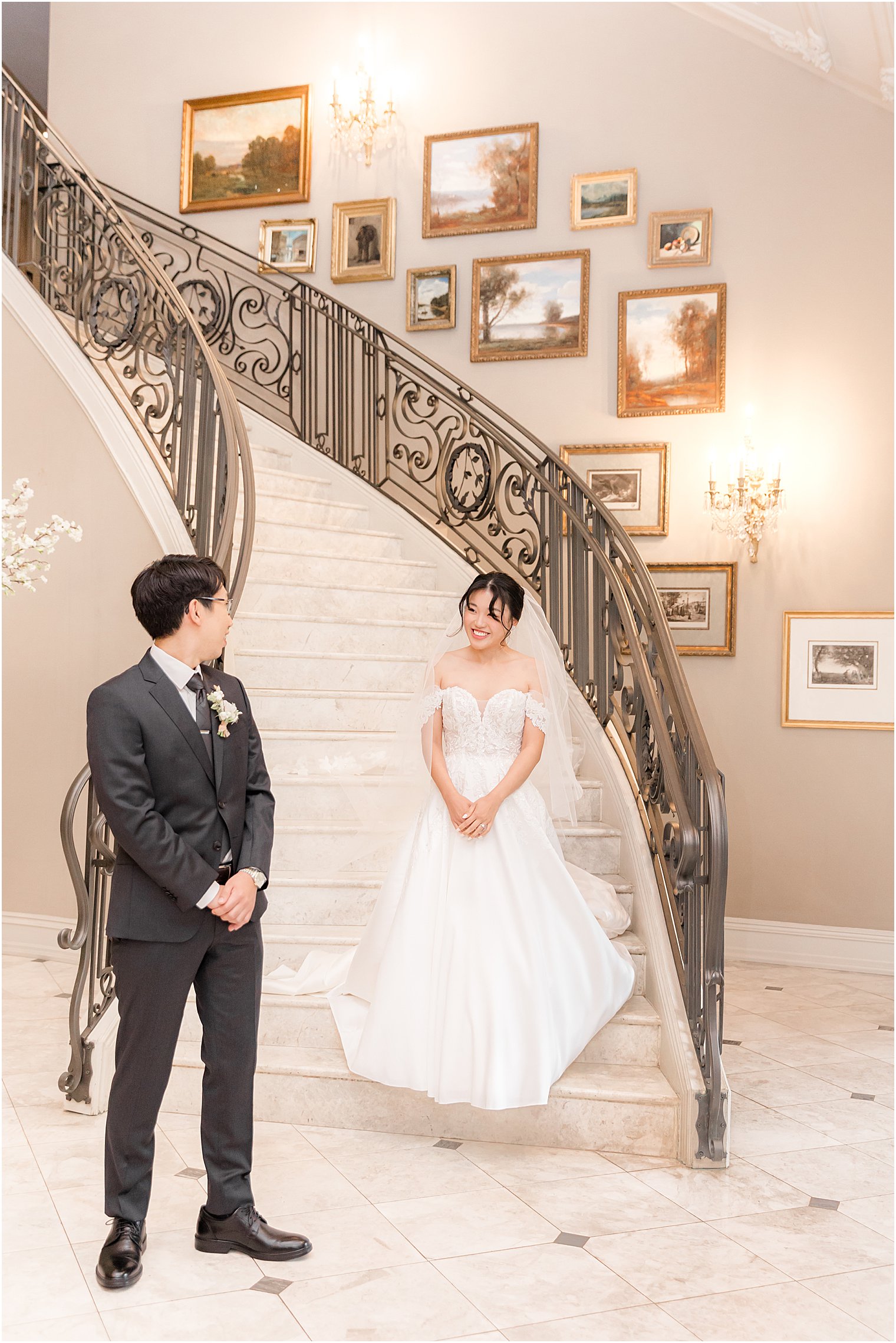 bride walks down steps to groom for first look at Park Chateau Estate