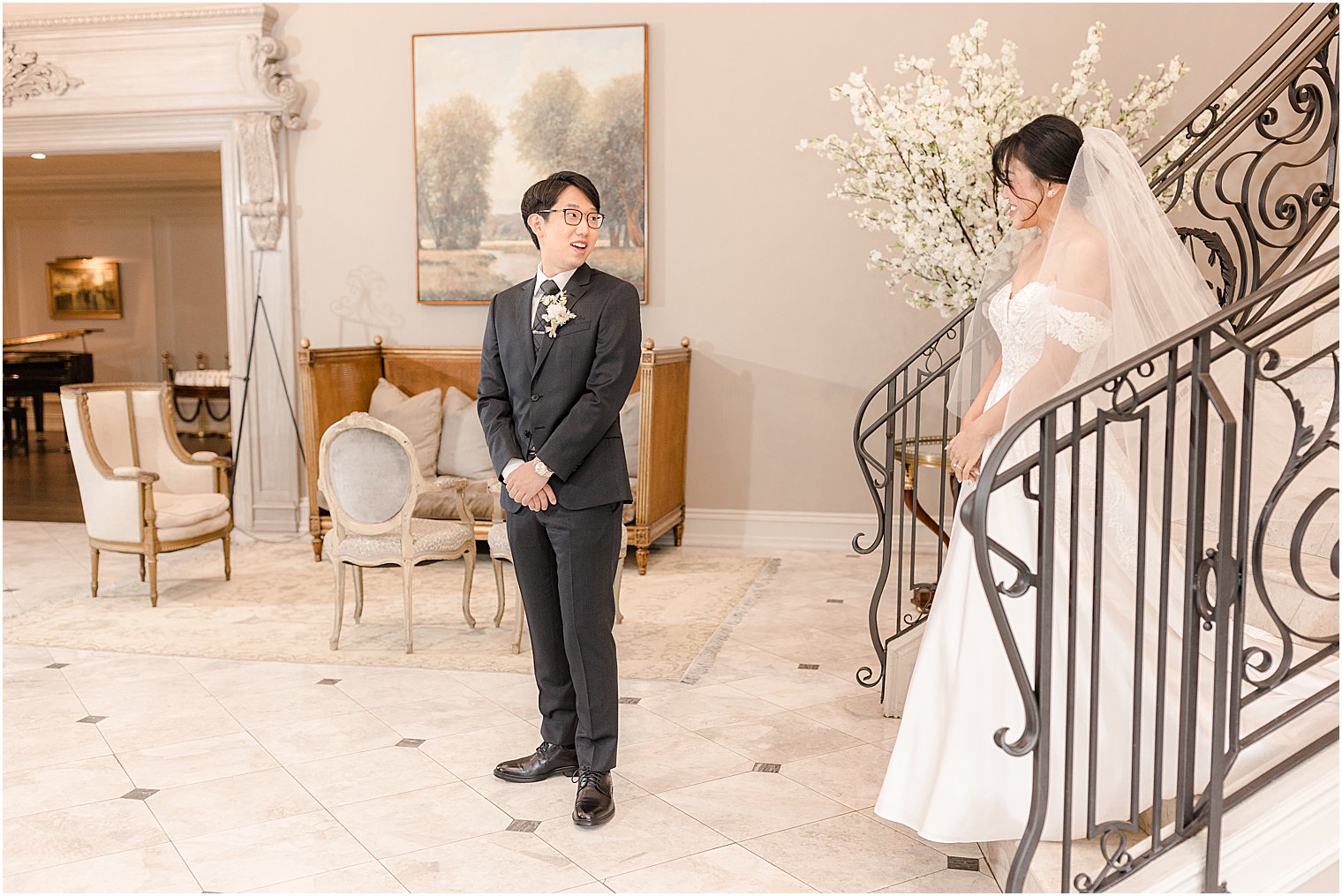 bride looks at groom on steps for first look