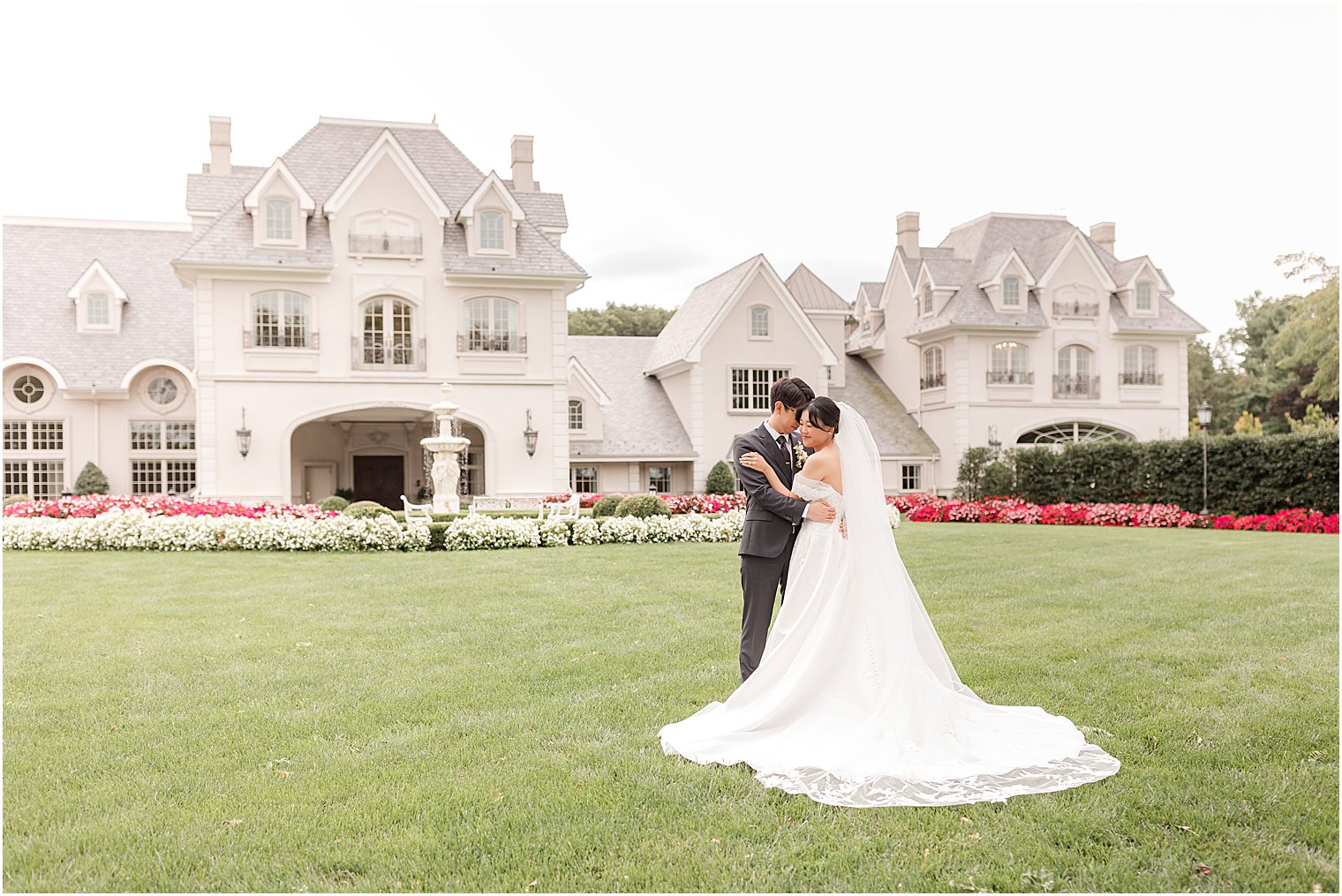 bride and groom stand on lawn out front of Park Chateau Estate