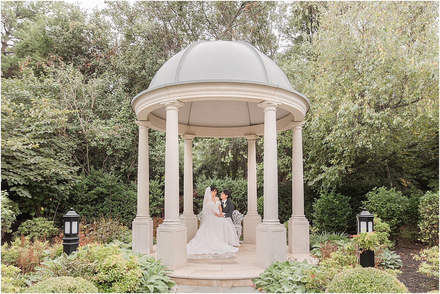 newlyweds pose under gazebo in Park Chateau Estate