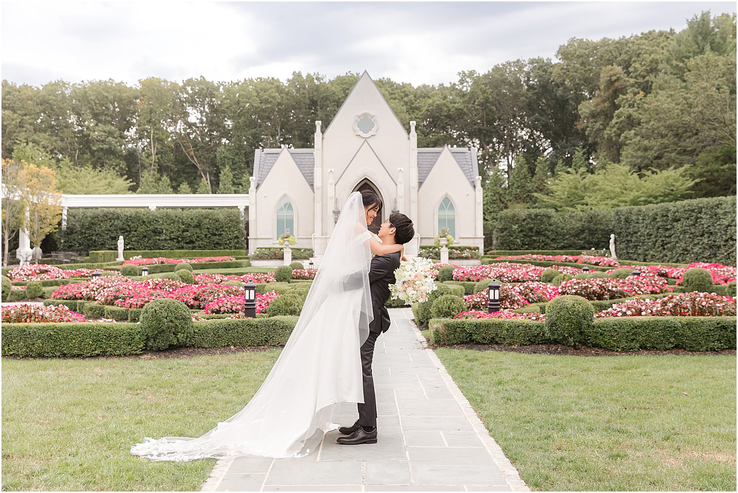 groom lifts bride outside chapel in New Jersey 