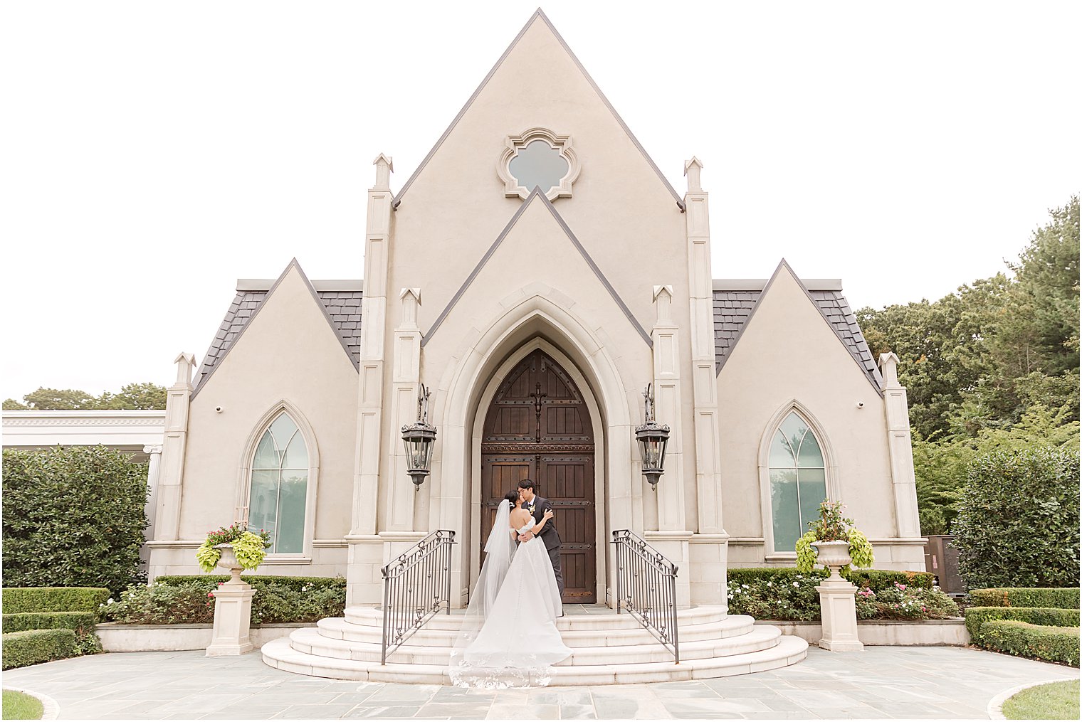 newlyweds stand on steps of chapel at Park Chateau Estate