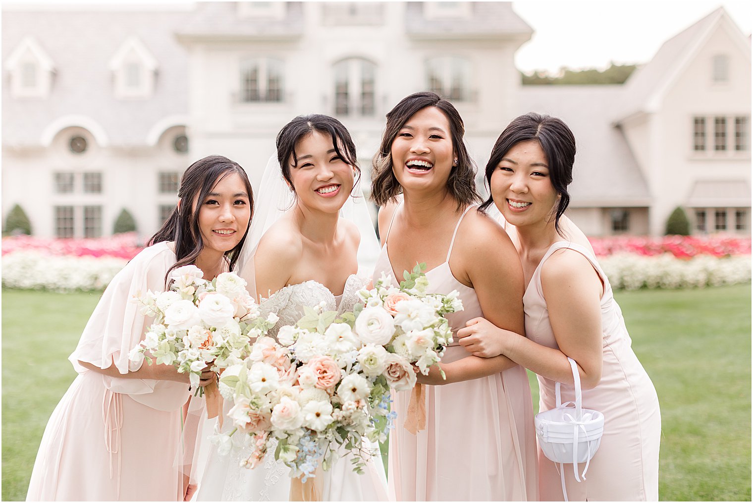 bride and bridesmaids in pink gowns laugh during fall wedding day 