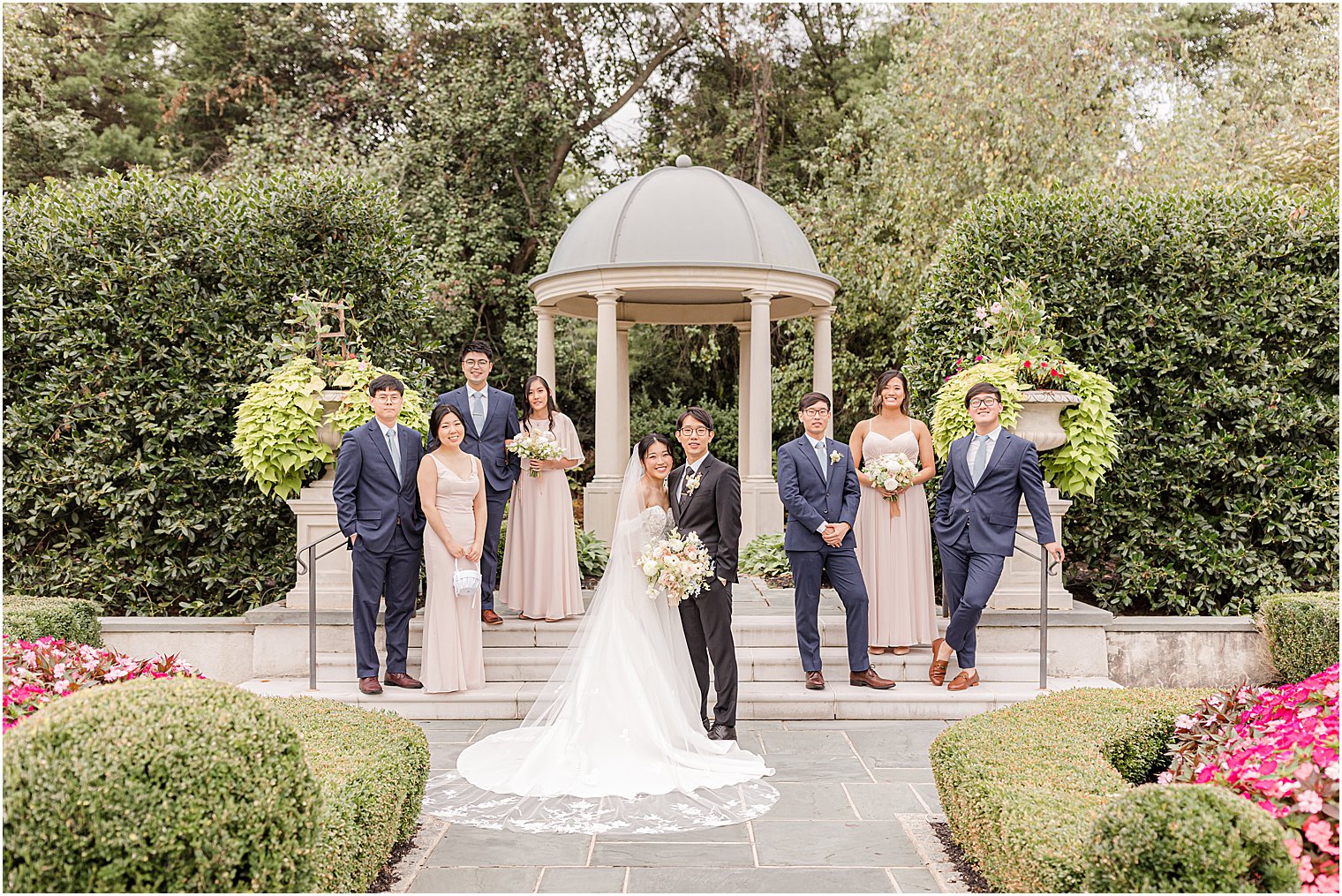 bride and groom pose with wedding party in garden at Park Chateau Estate