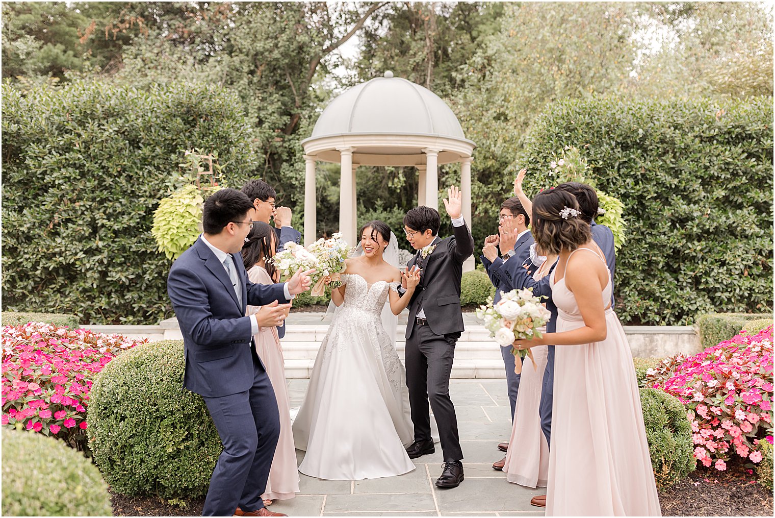 bride and groom dance with wedding party in gardens in New Jersey 