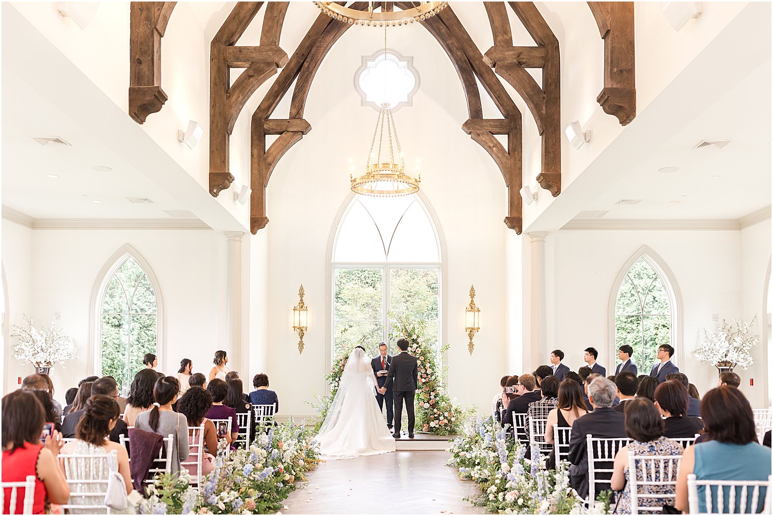 Park Chateau chapel wedding ceremony with florals along aisle 