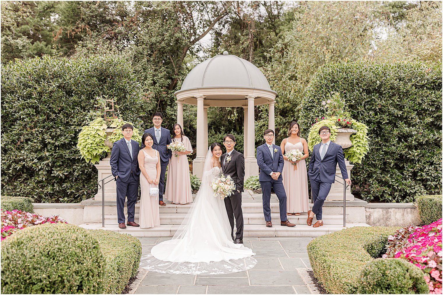 bride and groom hug outside gazebo at Park Chateau Estate in pink and blue