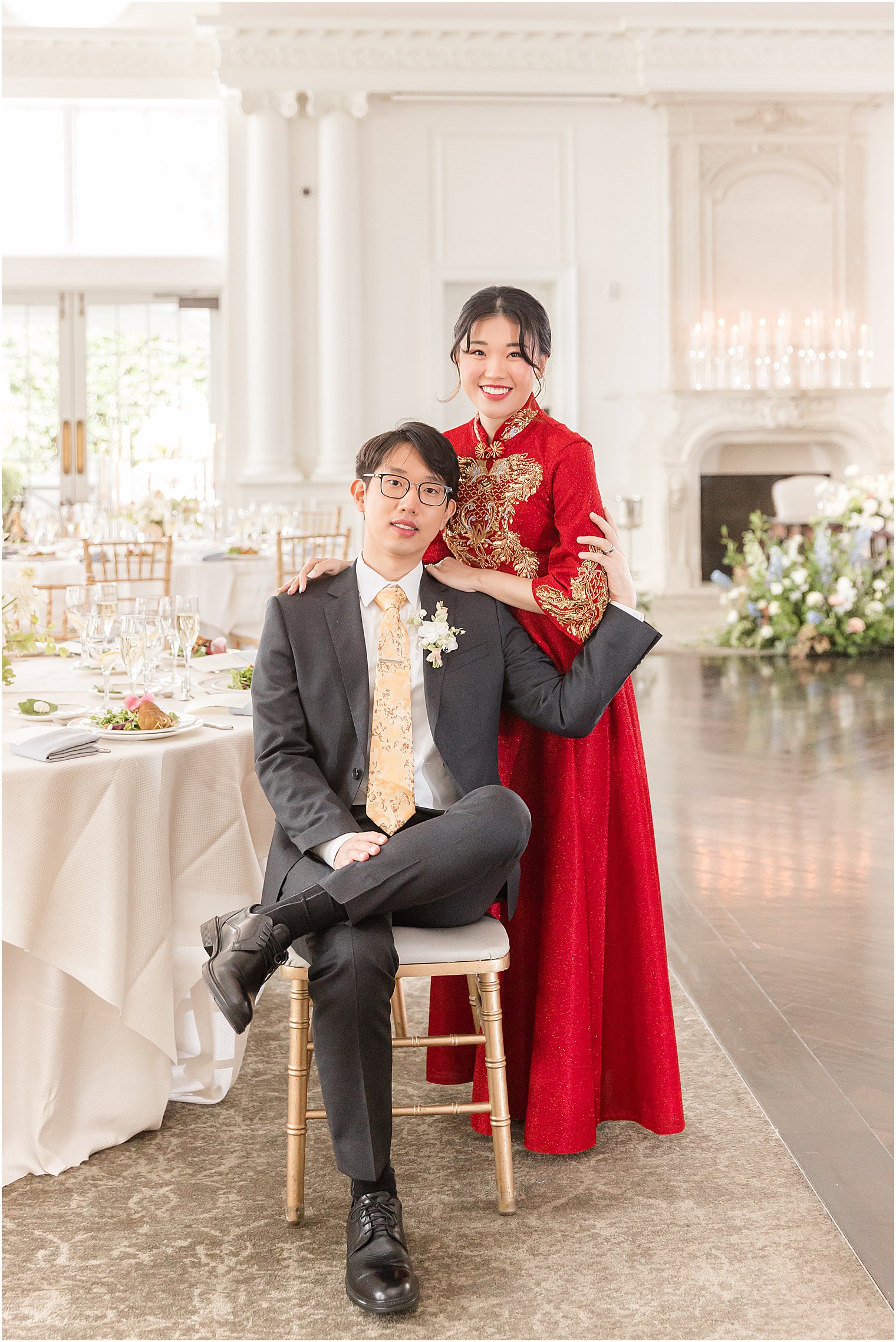 bride poses behind groom in traditional Chinese dress