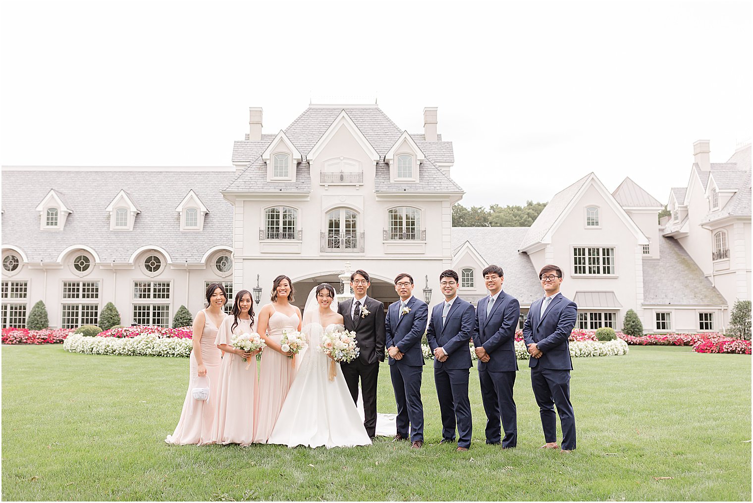 bride and groom stand with wedding party in Park Chateau Estate 