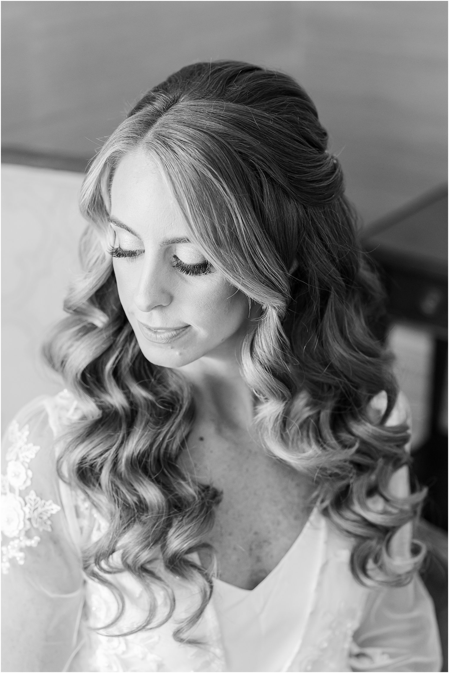black and white portrait of bride looking over shoulder in lace robe