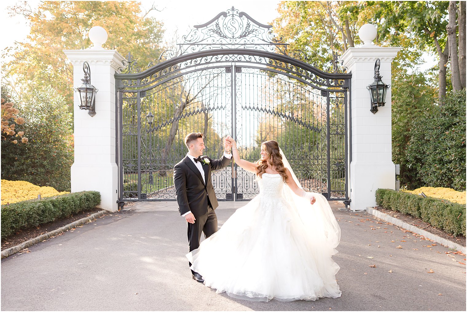 groom twirls bride outside gates of Shadowbrook at Shrewsbury