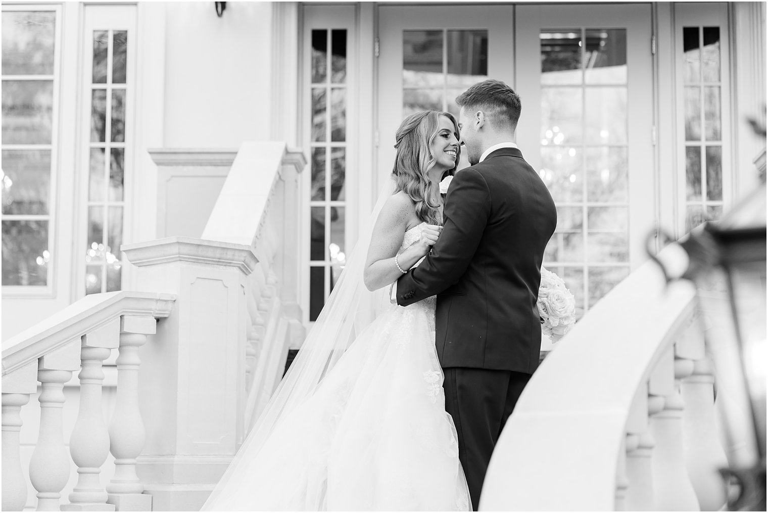 bride and groom lean in for kiss on steps at Shadowbrook at Shrewsbury