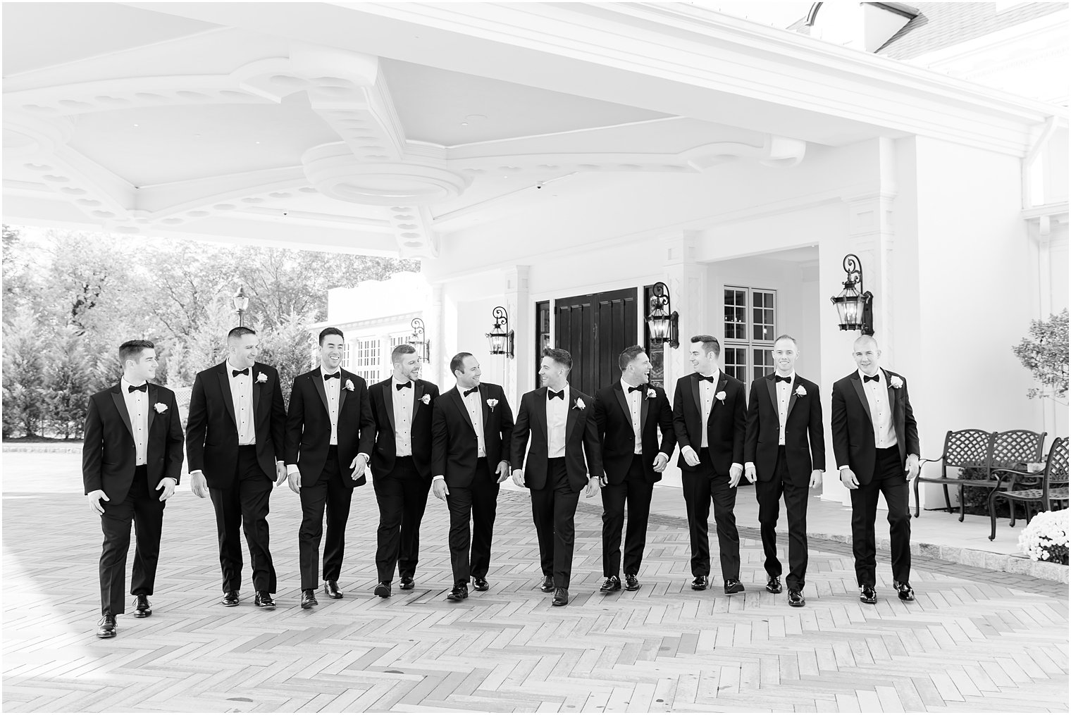 groom walks with groomsmen in black tuxes