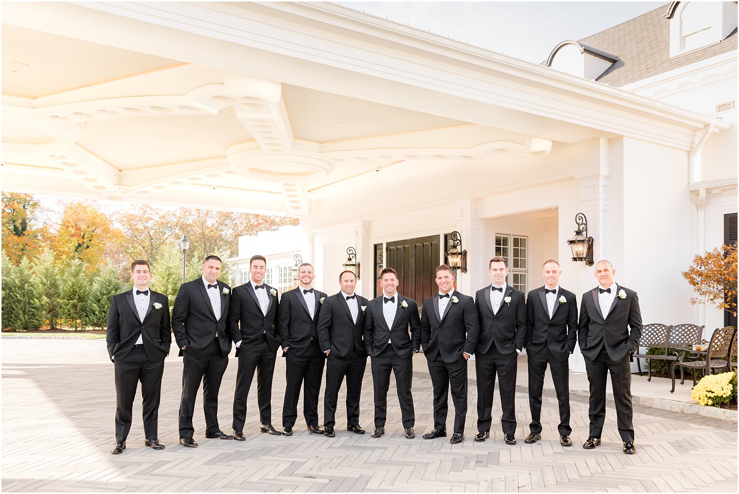 groom stands with groomsmen in classic black tuxes at Shadowbrook at Sherwsbury