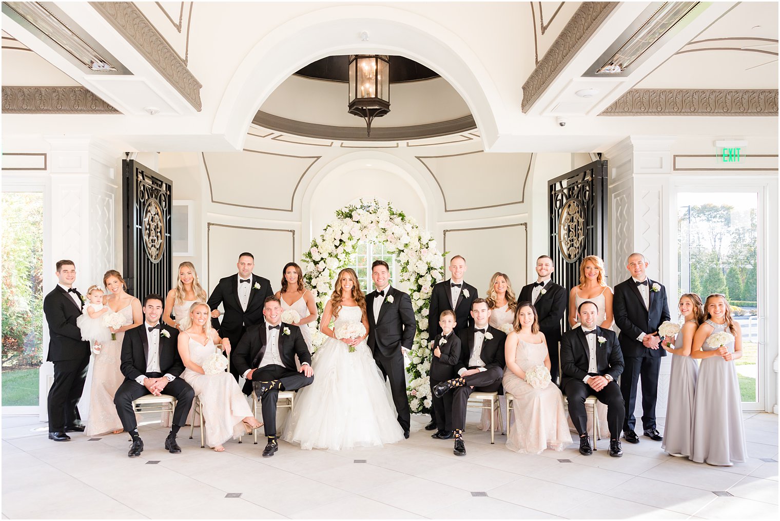 bride and groom stand with wedding party in pink and black at Shadowbrook at Sherwsbury