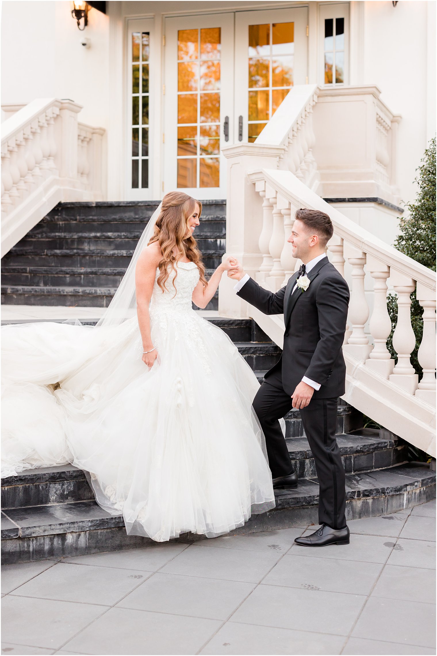 groom leads bride down staircase at Shadowbrook at Shrewsbury