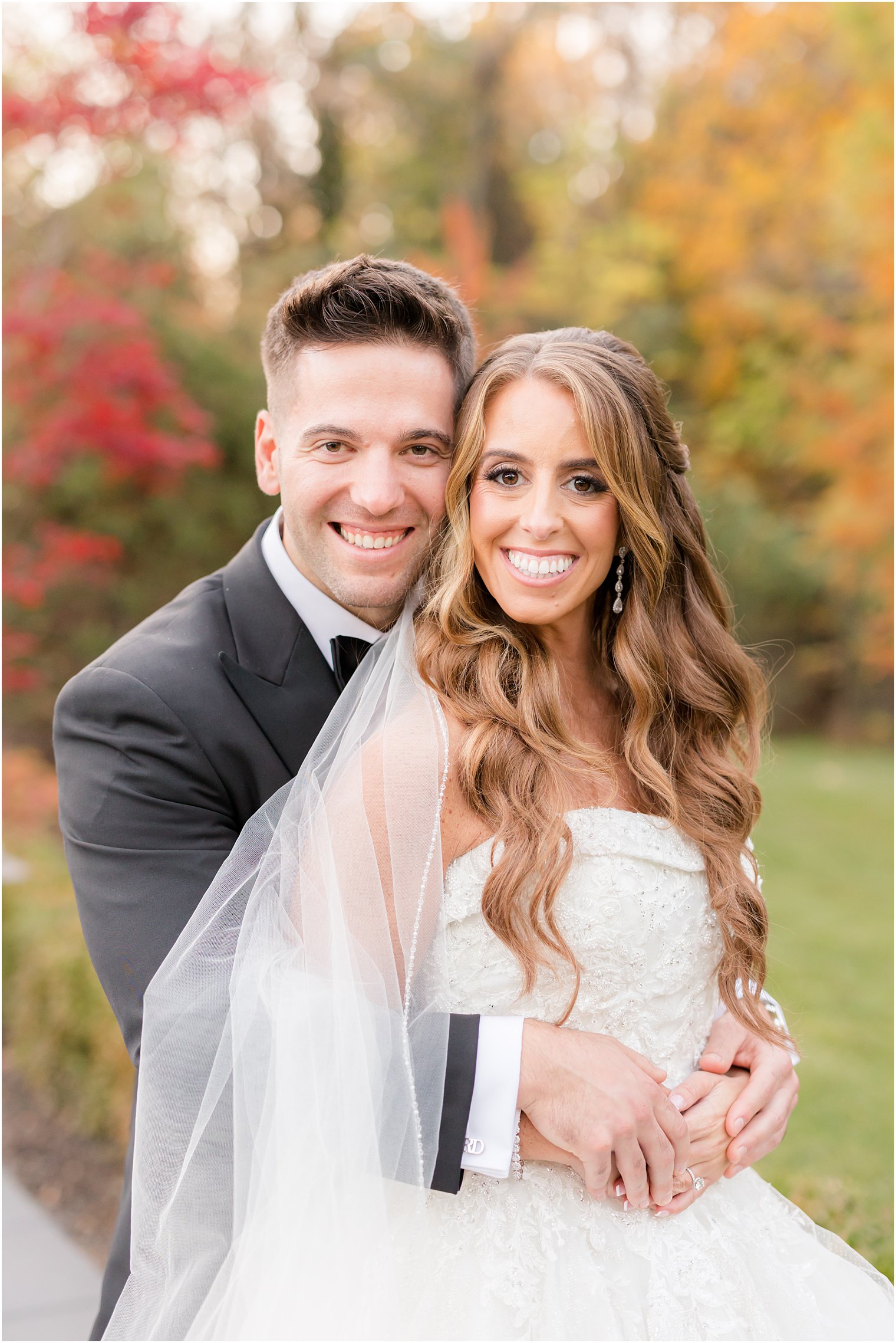 groom hugs bride in the fall standing at Shadowbrook at Sherwsbury