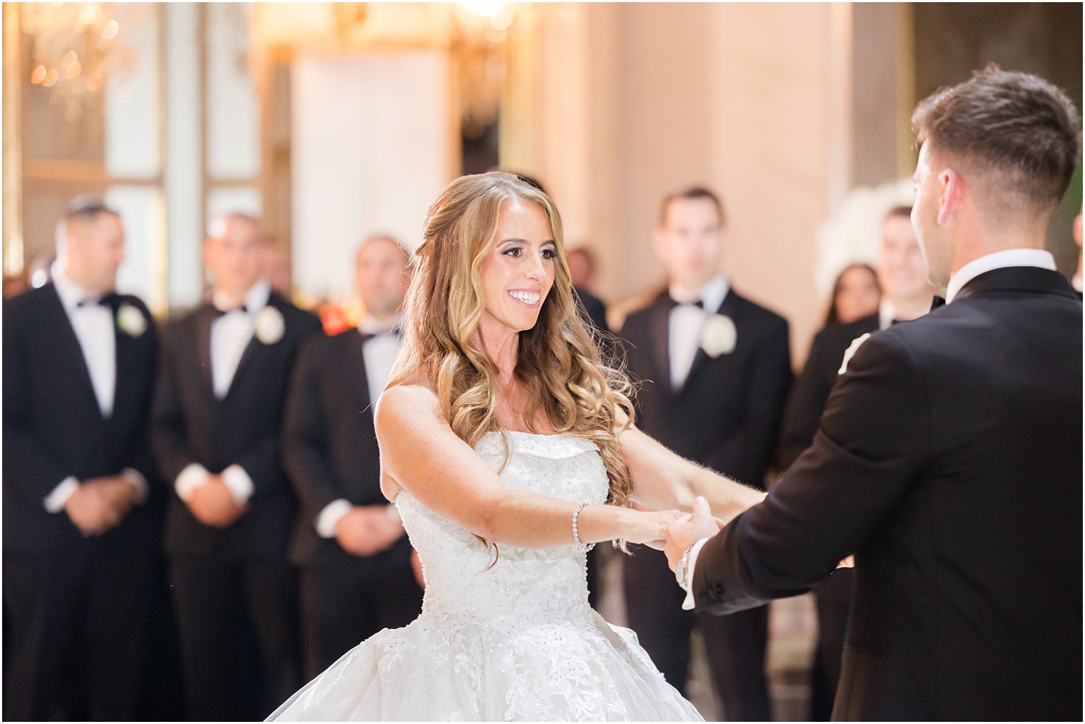 groom twirls bride with hands out during first dance