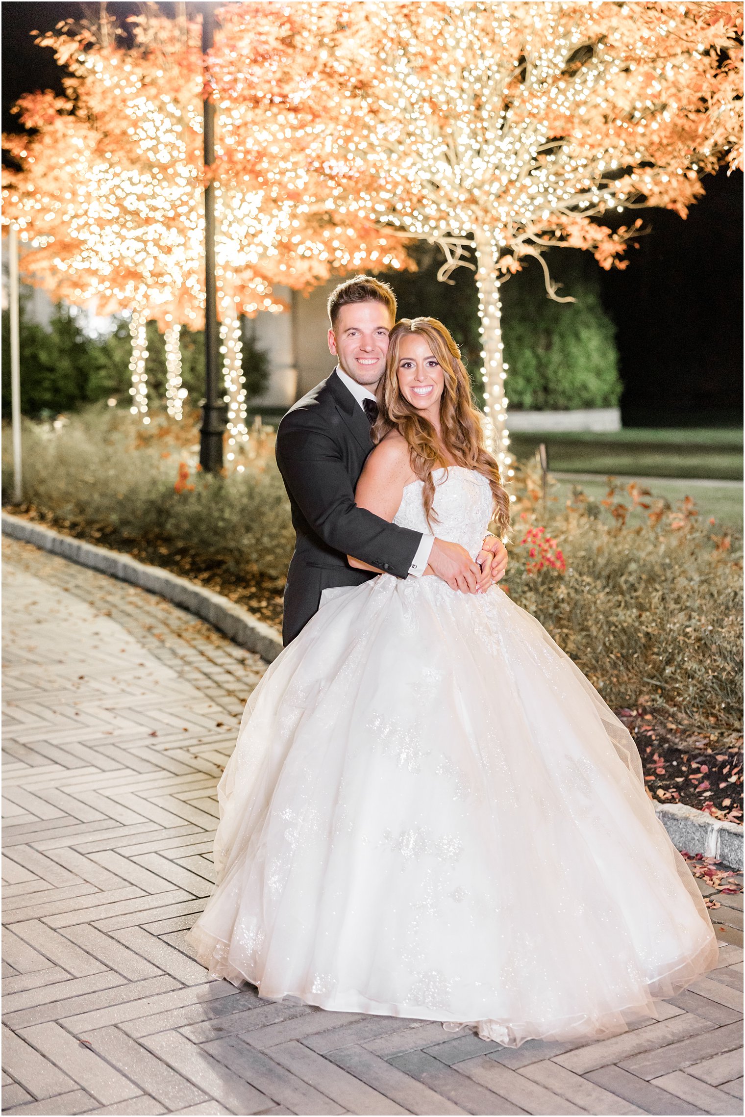 groom hugs bride from behind outside Shadowbrook at Shrewsbury