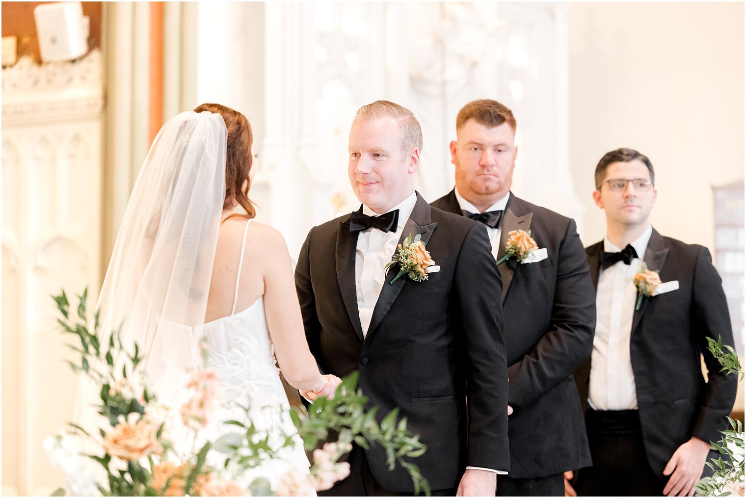 groom looks at bride during traditional ceremony at St. Peter's Church in Point Pleasant