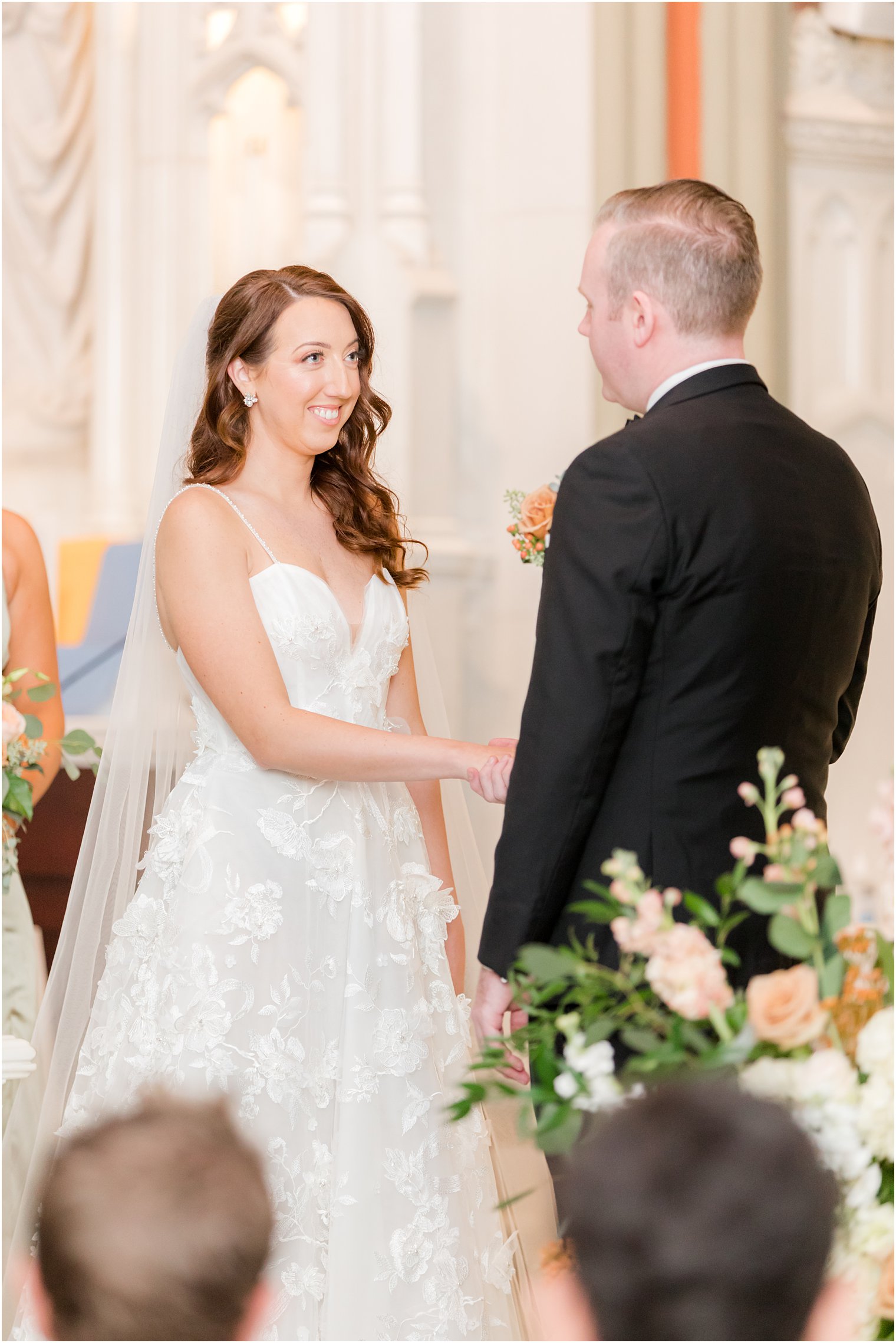 bride smiles at groom during traditional ceremony at St. Peter's Church in Point Pleasant