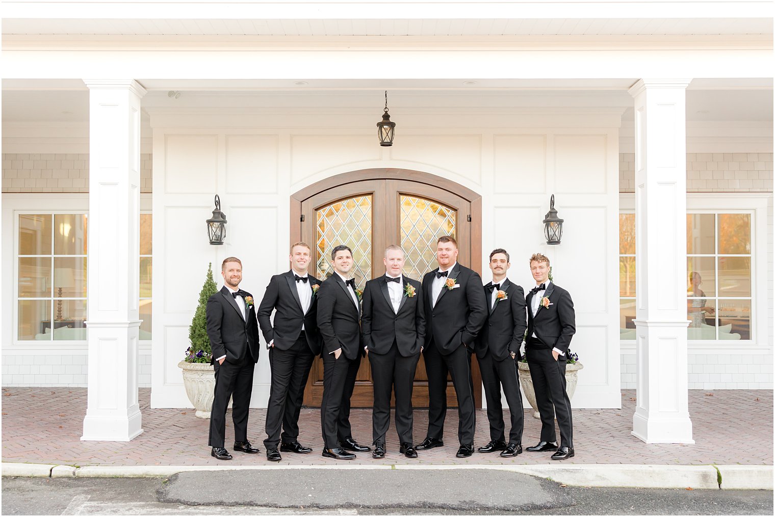 groom stand with groomsmen in black suits outside The Mill Lakeside Manor