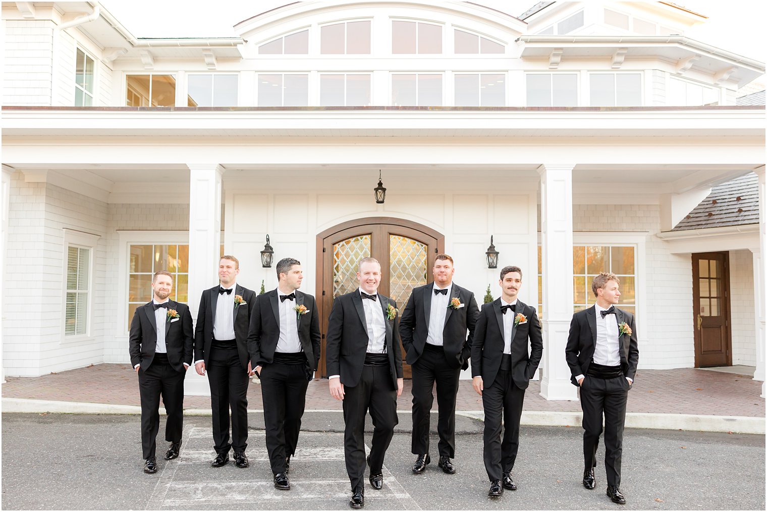 groom and groomsmen in classic tuxes walk outside The Mill Lakeside Manor