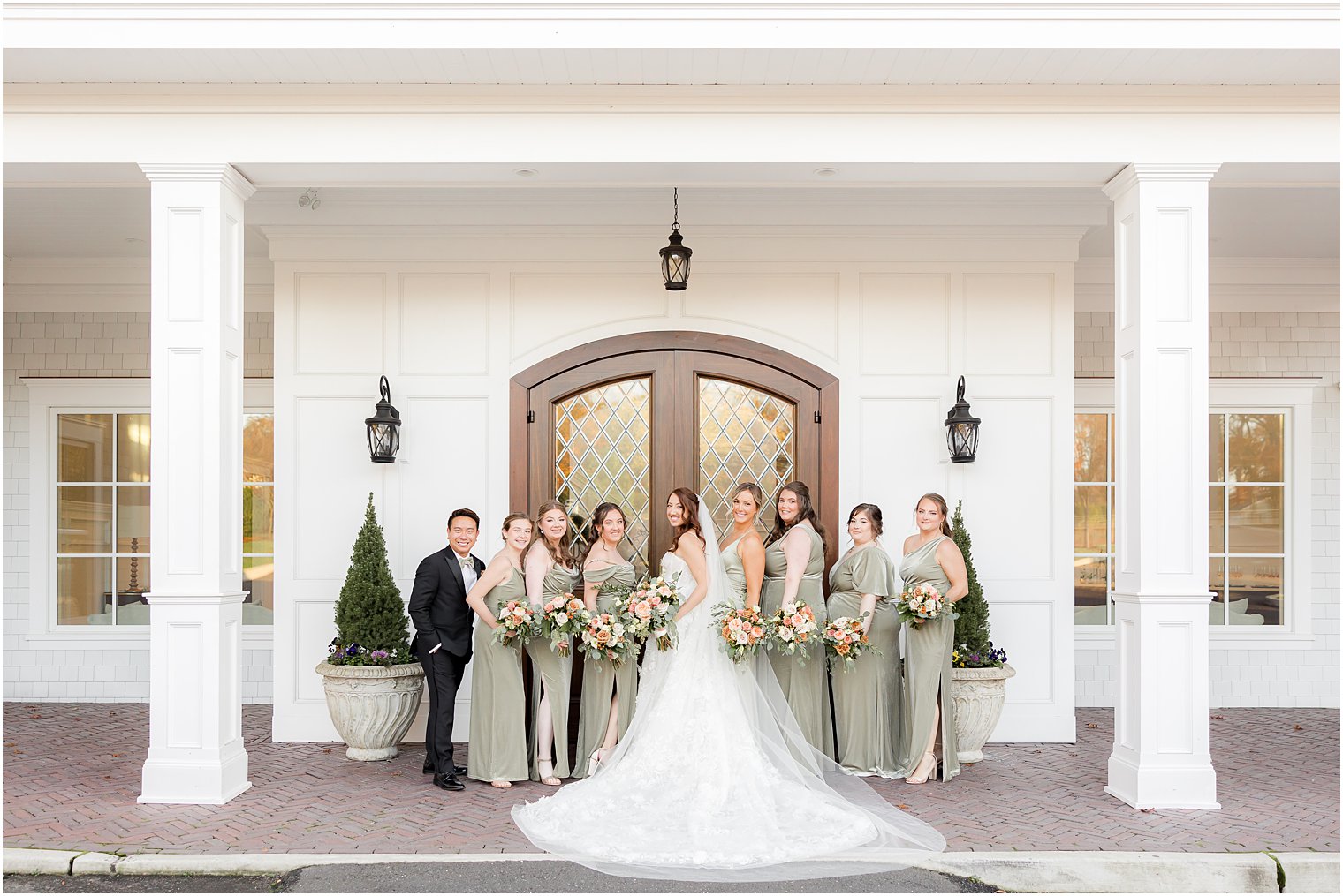 bride and bridal party stand by wooden door at The Mill Lakeside Manor