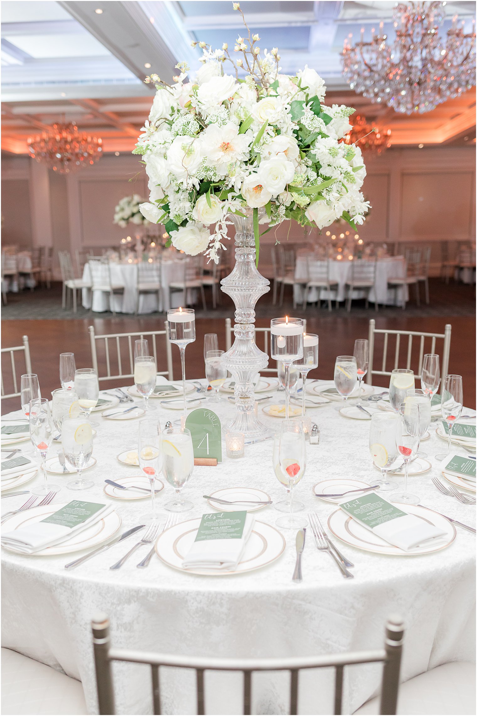 tall floral centerpiece with mint green accents on table 