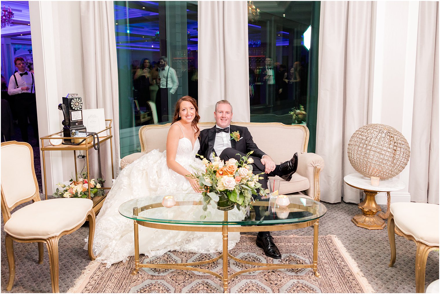 bride and groom sit on seating display at The Mill Lakeside Manor reception 