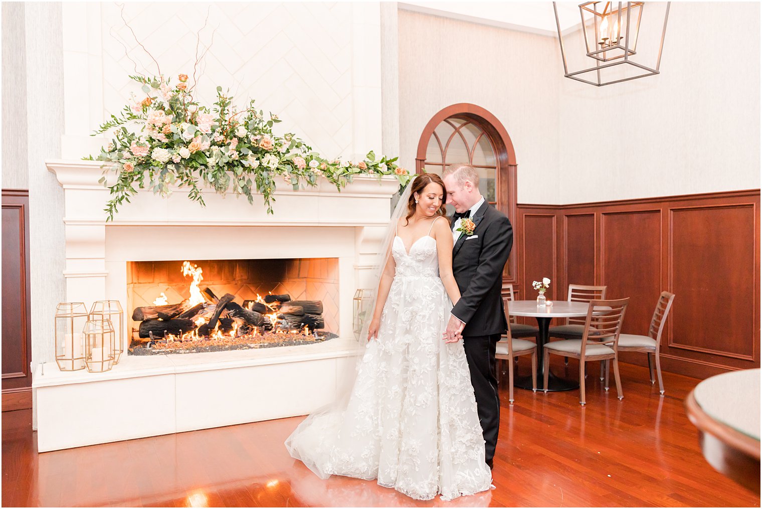 bride and groom hug by white fireplace at The Mill Lakeside Manor 