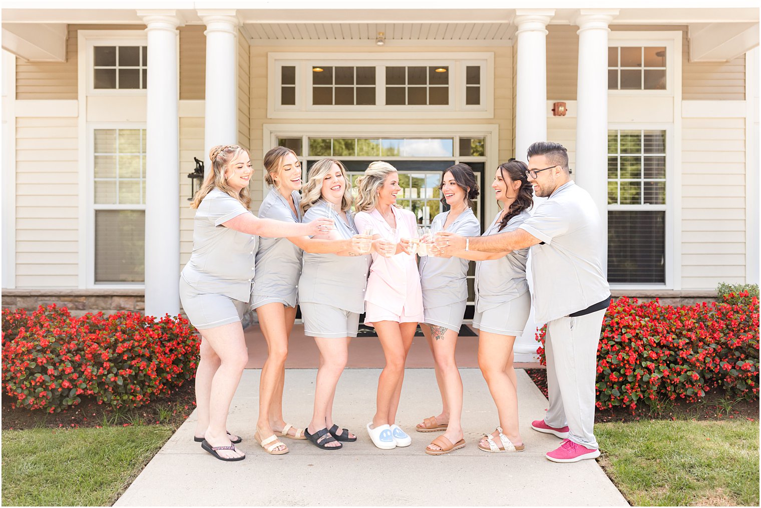 bride poses with wedding party before fall wedding at the Mill Lakeside Manor