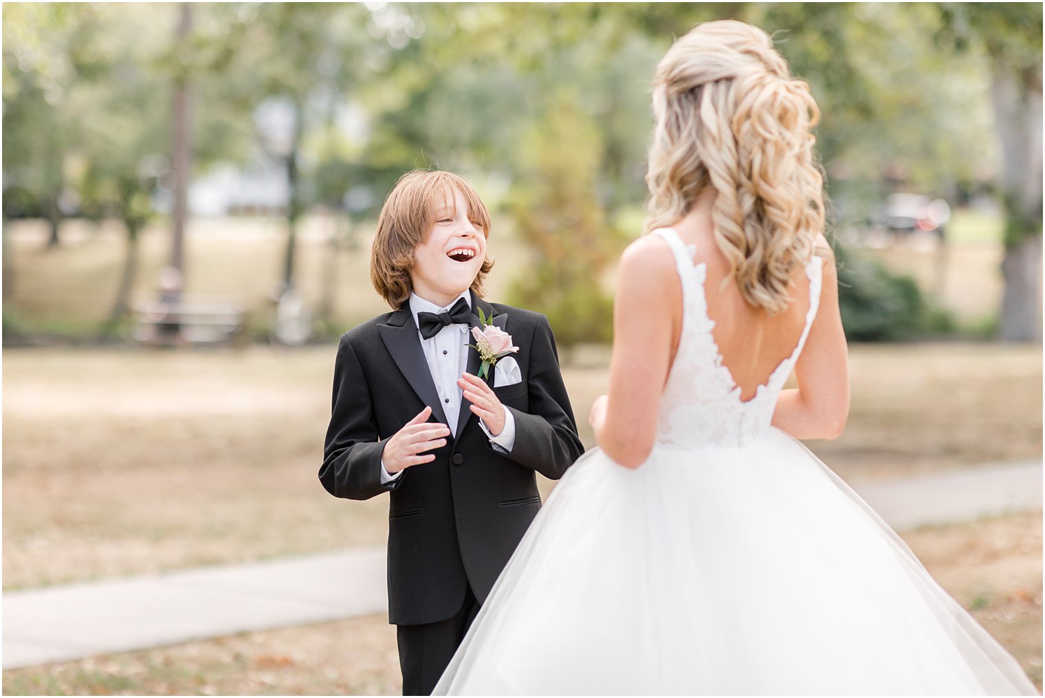 brother smiles at bride during first look