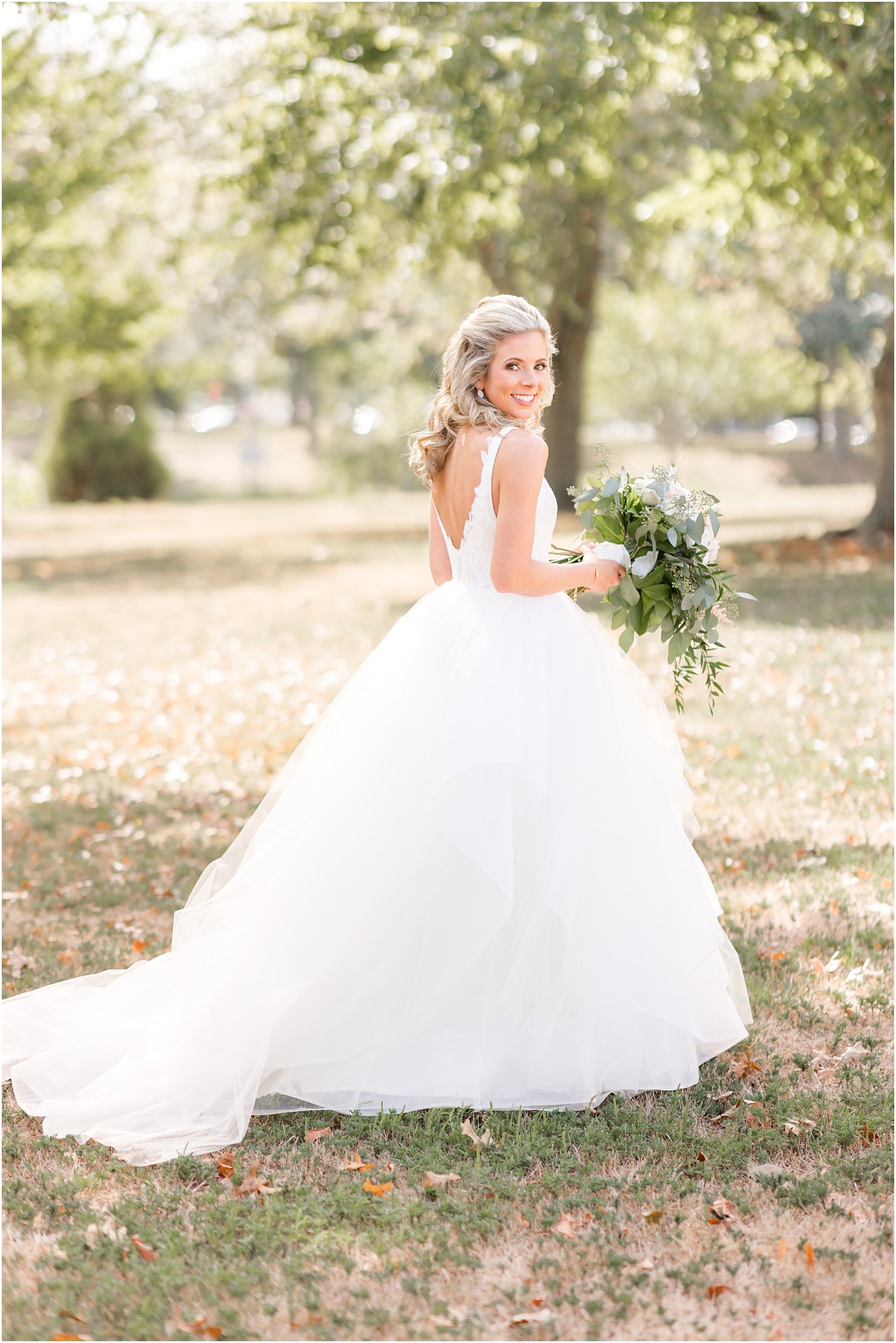 bridal portrait in park with bride looking over shoulder 