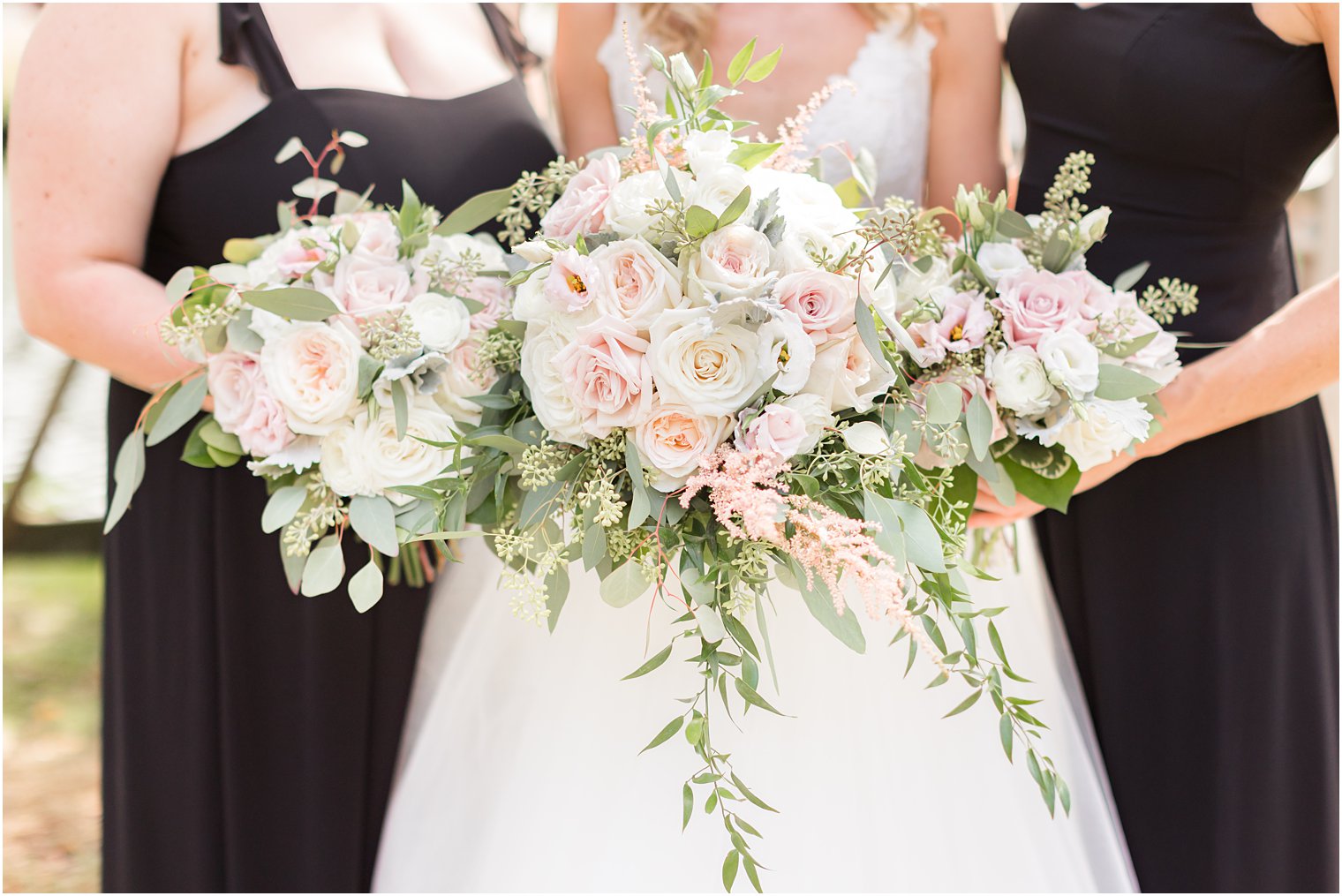 bride and bridesmaids hold bouquet of pink and white flowers 