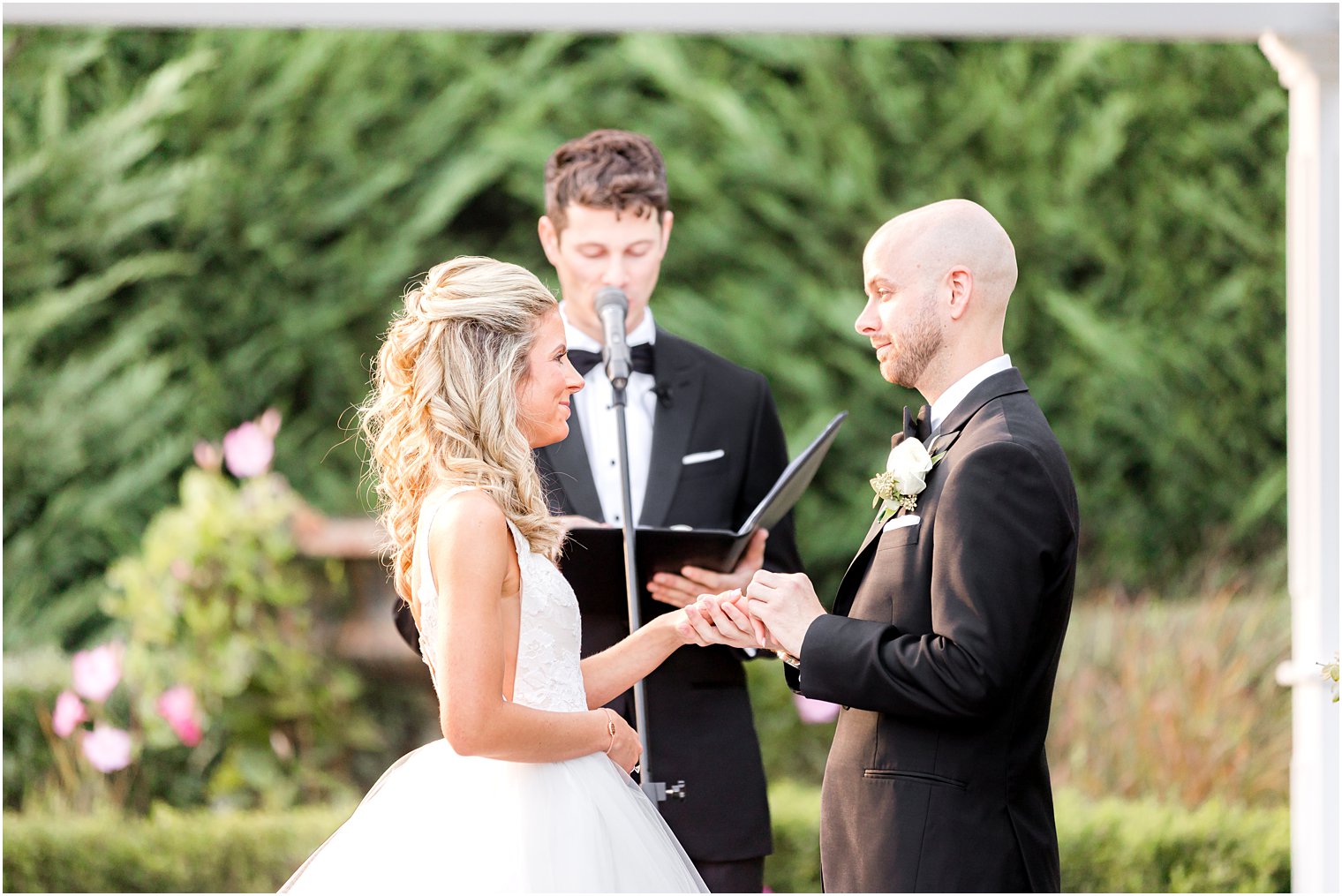 bride and groom hold hands exchanging vows during fall wedding ceremony at The Mill Lakeside Manor