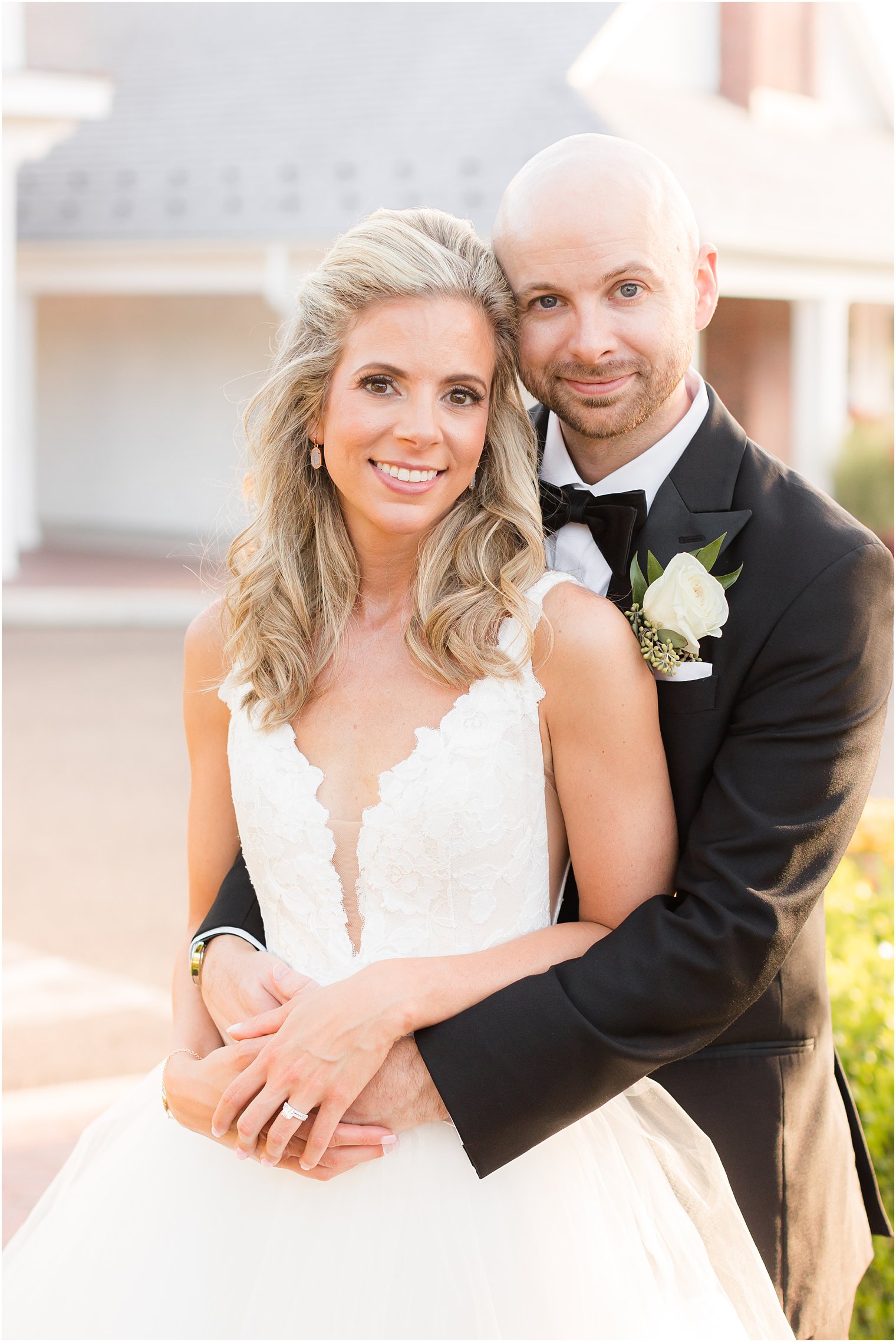 groom hugs bride from behind during NJ wedding photos